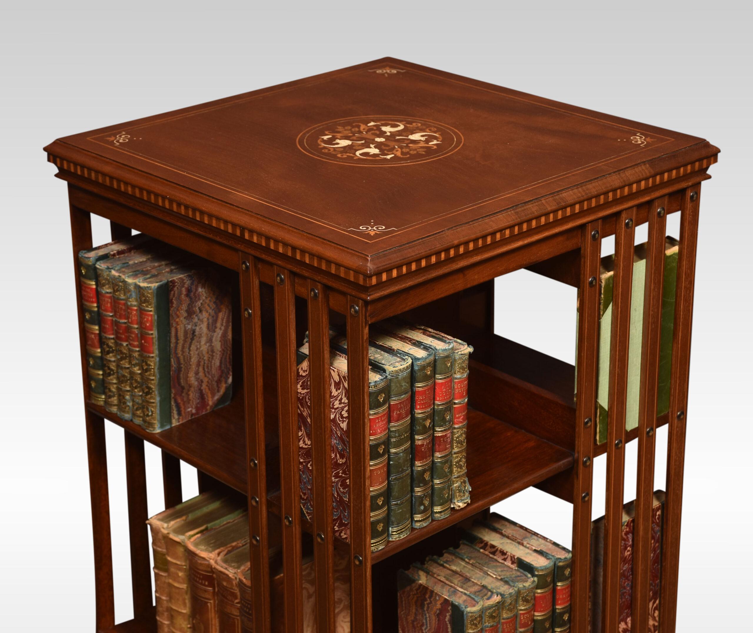 Revolving bookcase the foliated and line inlaid top, above an arrangement of shelves raised up on a cruciform base with castors almost certainly by Maple & Co.
Dimensions
Height 34.5 inches
Width 20 inches
Depth 20 inches.
