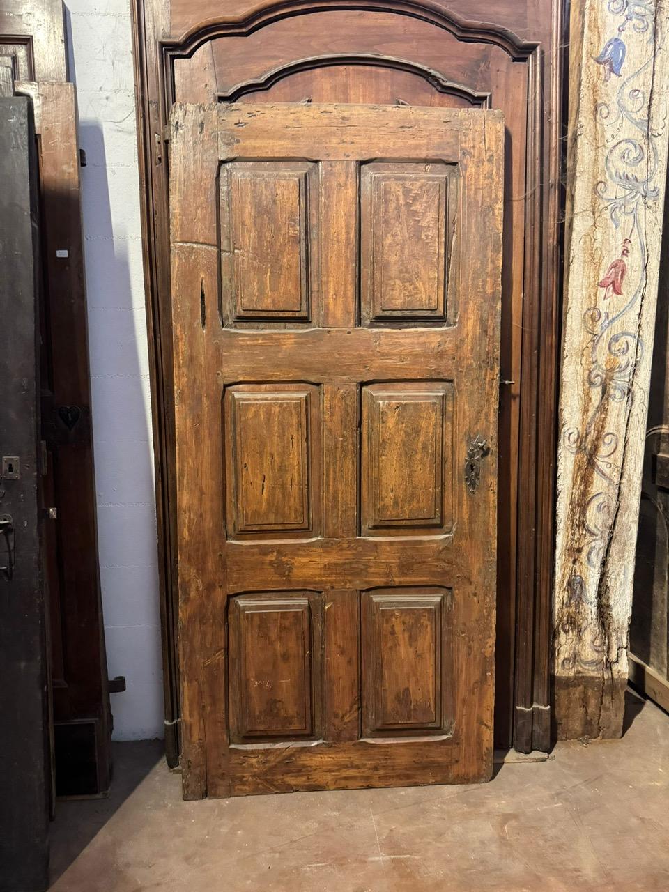 Antique single-leaf walnut door with six carved rectangular panels. Originally frameless, it can also be used as a panel or sliding door. It has wall brackets for a left-handed opening. Smooth back. Original from the 18th century, made in