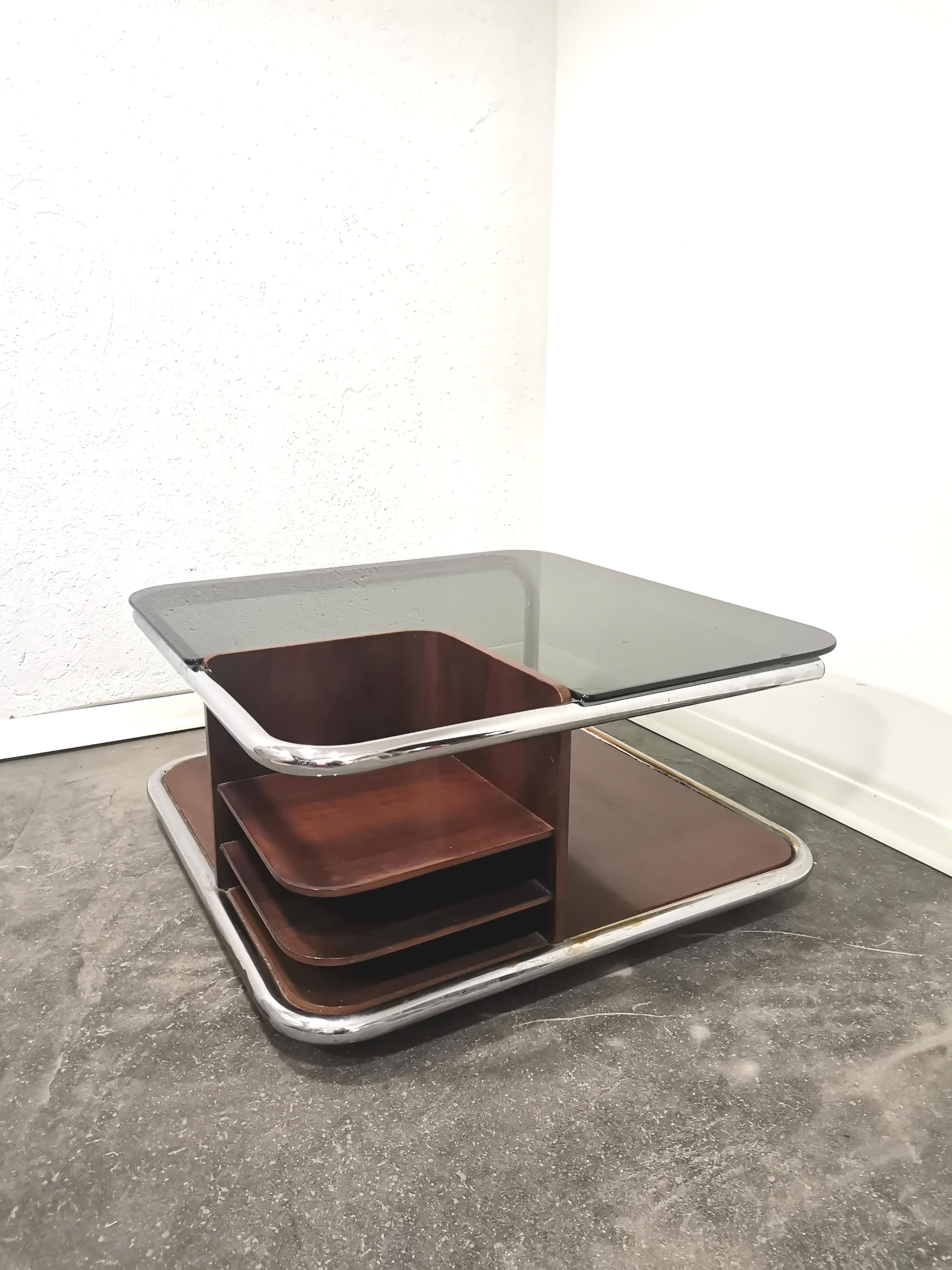 Nice square coffee table with 2 levels on wheels.

Italian  1970’s – this piece was made with original smoked glass, walnut wood and a metal tube without any welding.

Length 78 cm, Height 38 cm, Depth 78 cm