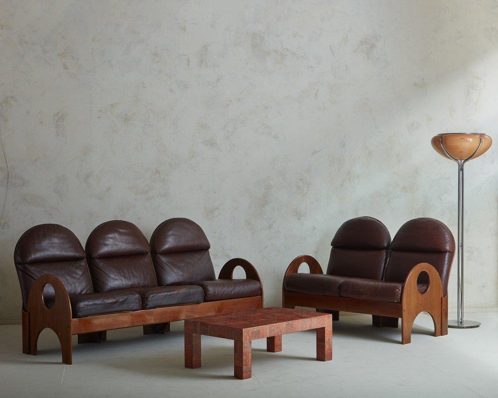 A two-seat  ‘Arcata’ sofa designed by Gae Aulenti for Poltronova in 1968. This sculptural sofa features a walnut frame with an arched seat back and arms, whose curves are emphasized by circular and demilune cutout details. This sofa retains its