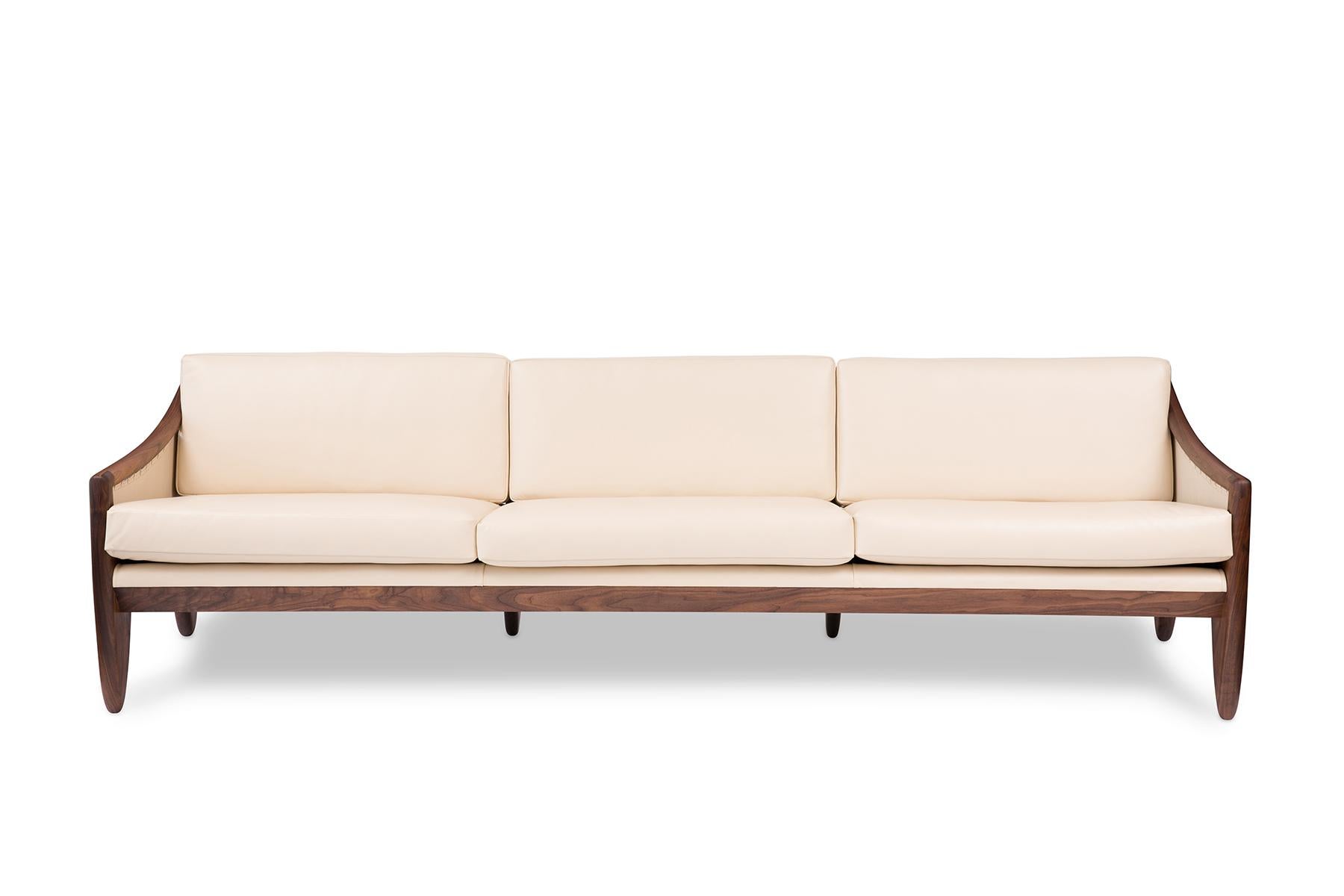 Designed and handcrafted after a unique one-of-a-kind 1957 sofa by designer Allen Ditson, this couch's stunning walnut frame took over 6 weeks of daily sculpting to complete. The sofa is also upholstered in a fine buttery cream Edelman leather with