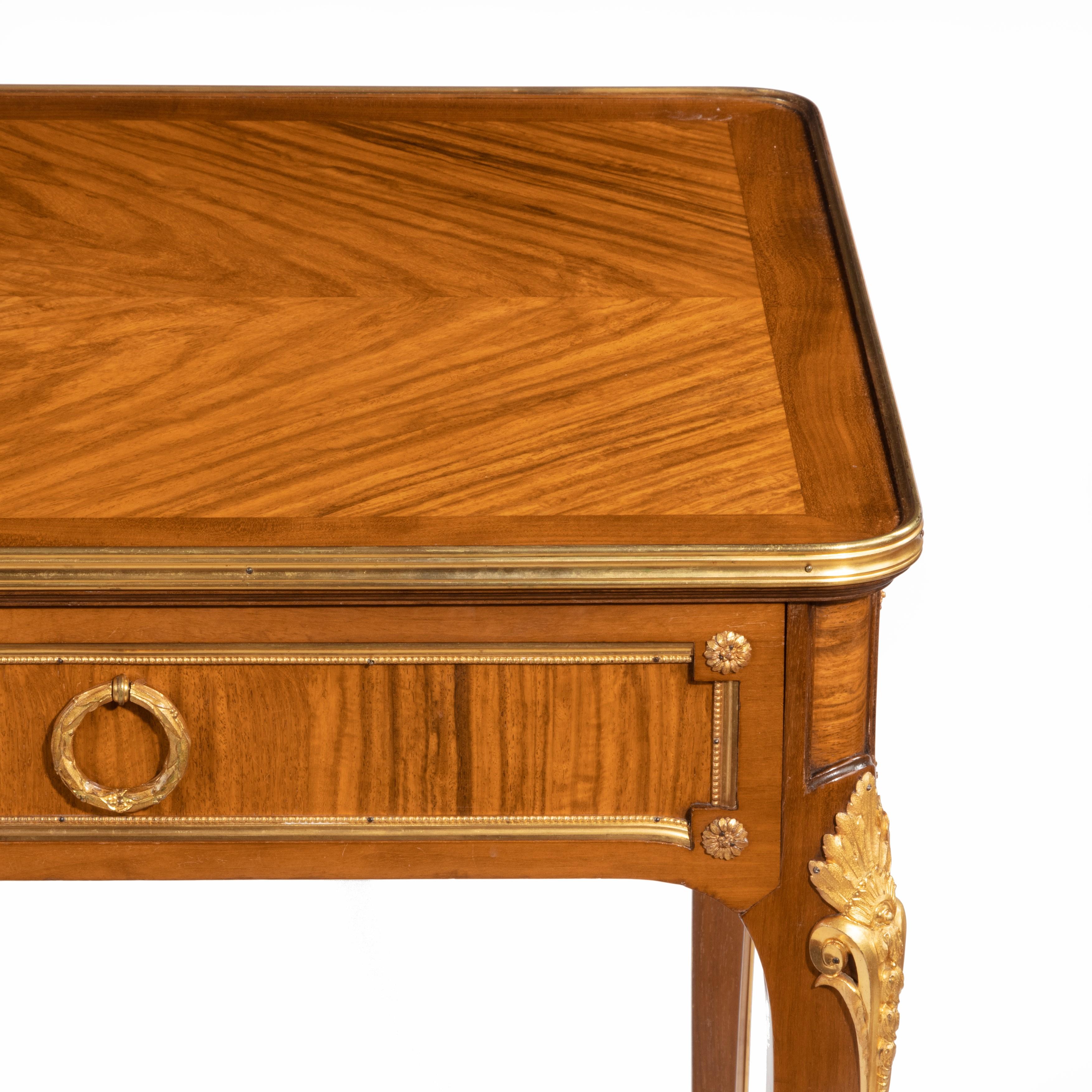A walnut library table by Alexandre Chevrié, of rectangular form with two frieze drawers set above
slender cabriole legs, decorated with quarter veneers, mahogany banding and classical ormolu
mounts, signed ‘Chevrié á Paris’, French, circa 1880.