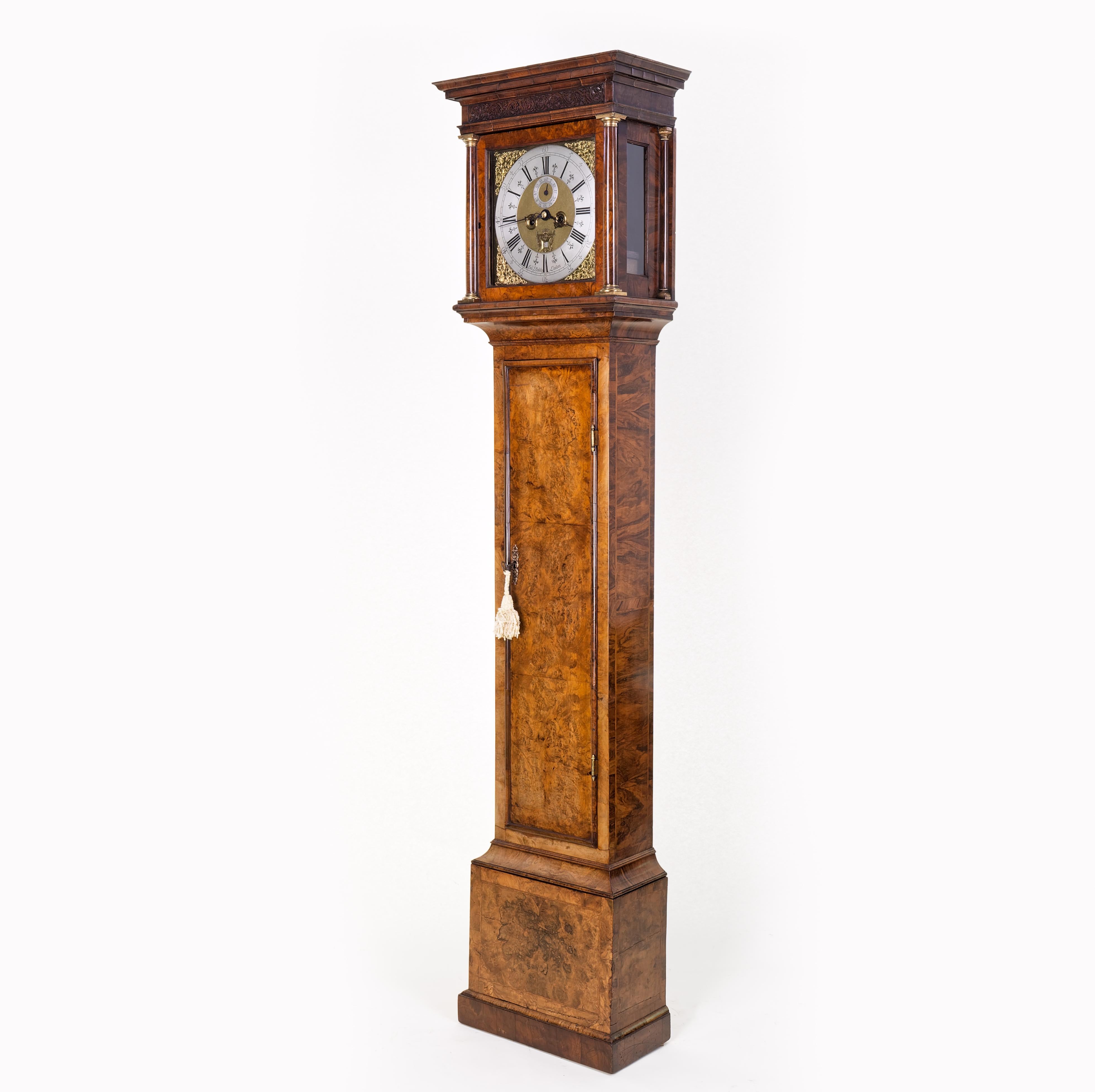 An very fine quality burr walnut longcase clock from the Quenn Anne period with exceptionally well patinated case. With moulded stepped cornice above a fretwork border and silvered dial surrounded by brass spandrels. The face with seconds ring and