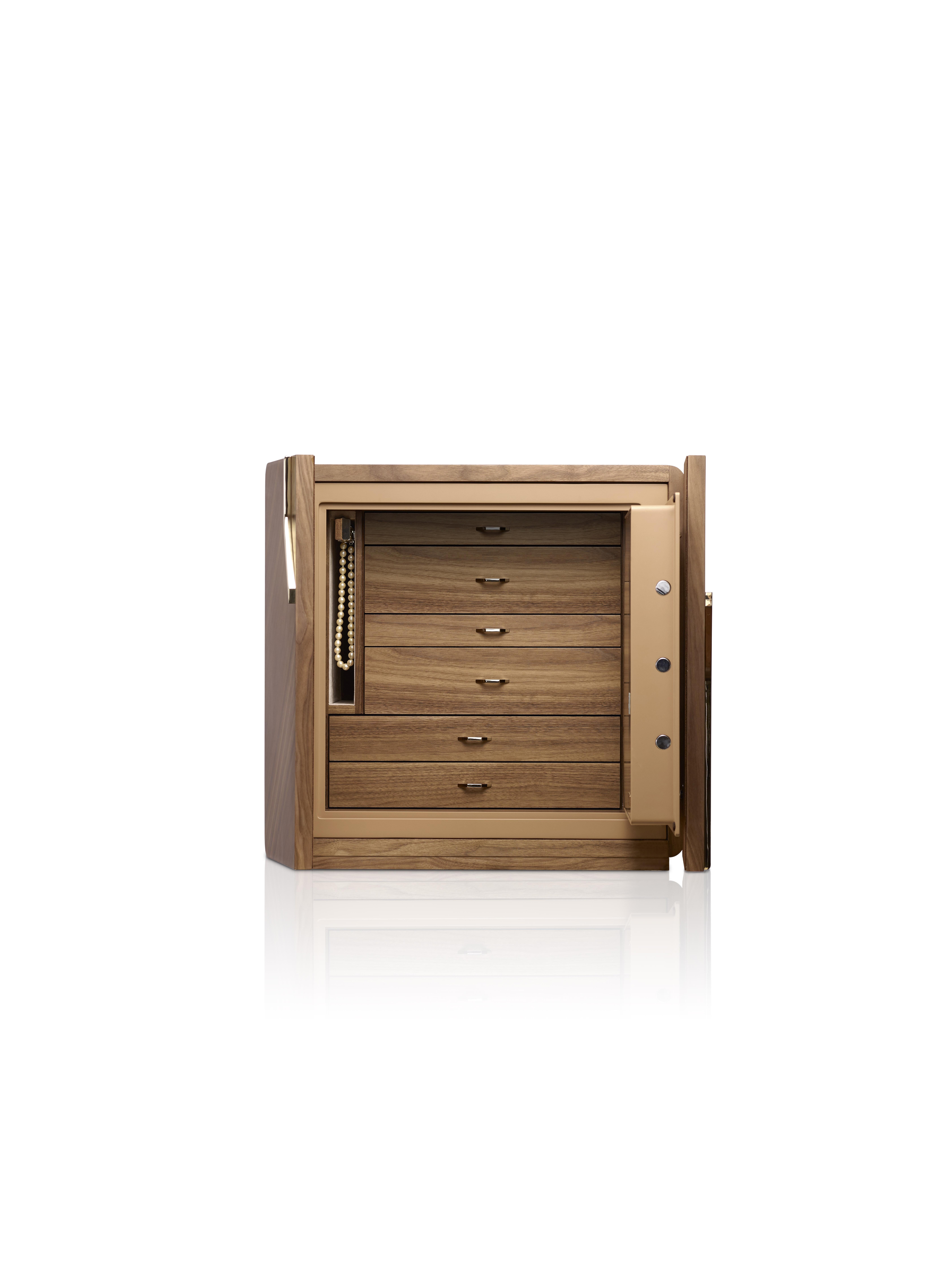 Polished walnut armoured chest, matte finish,
24 karats gold plated accessories. Round
handle with biometric opening device and
emergency key integrated. Inside pull out
necklace holder and drawers lined for jewellery.
