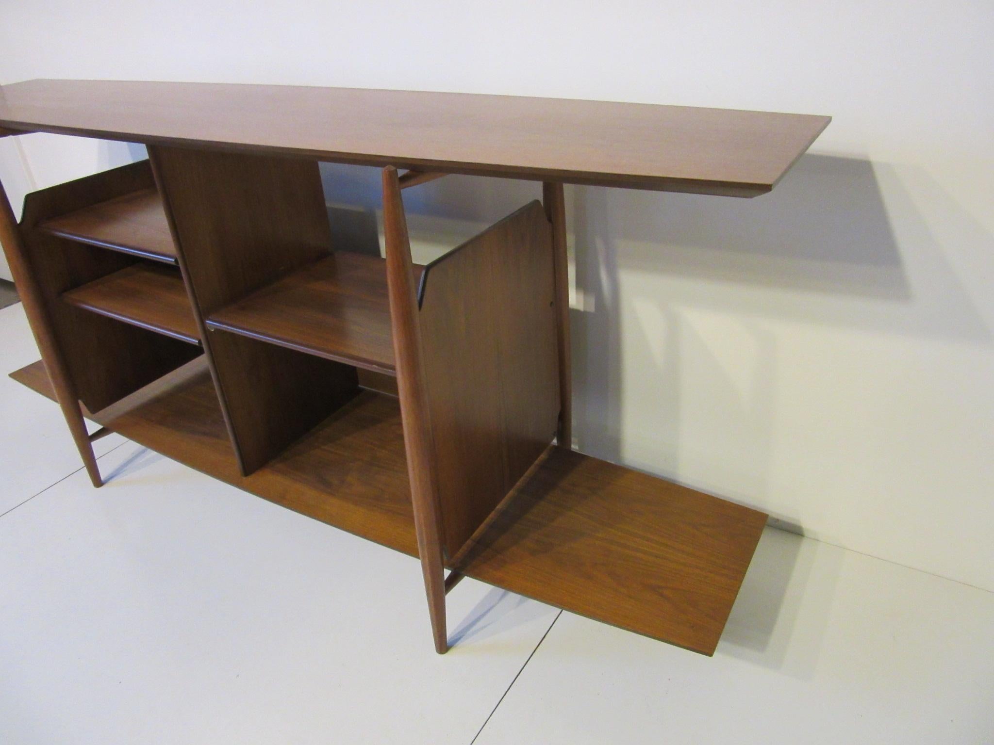A medium toned walnut Stereo / Media shelving unit with two adjustable shelves and one pull out shelve for a turntable or other media device. Amp and tuner placement on the adjustable shelves with open back for wires. Additional storage to each side