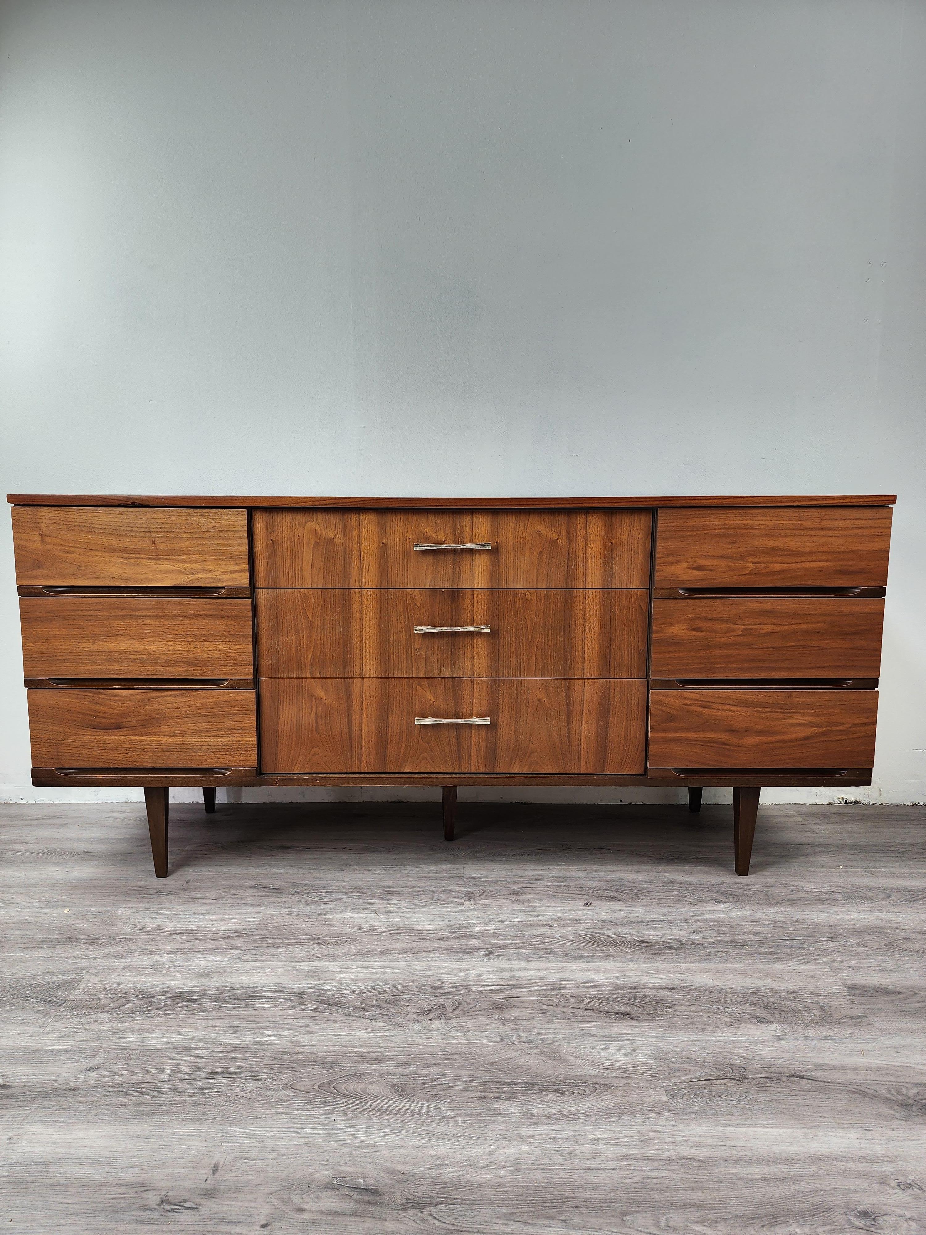 This lovely walnut dresser was created by Harmony House in the 1960s. It was purchased from the family of the original owner and was professionally restored and refinished, along with the matching tall chest. The grain of the 60 year old walnut is