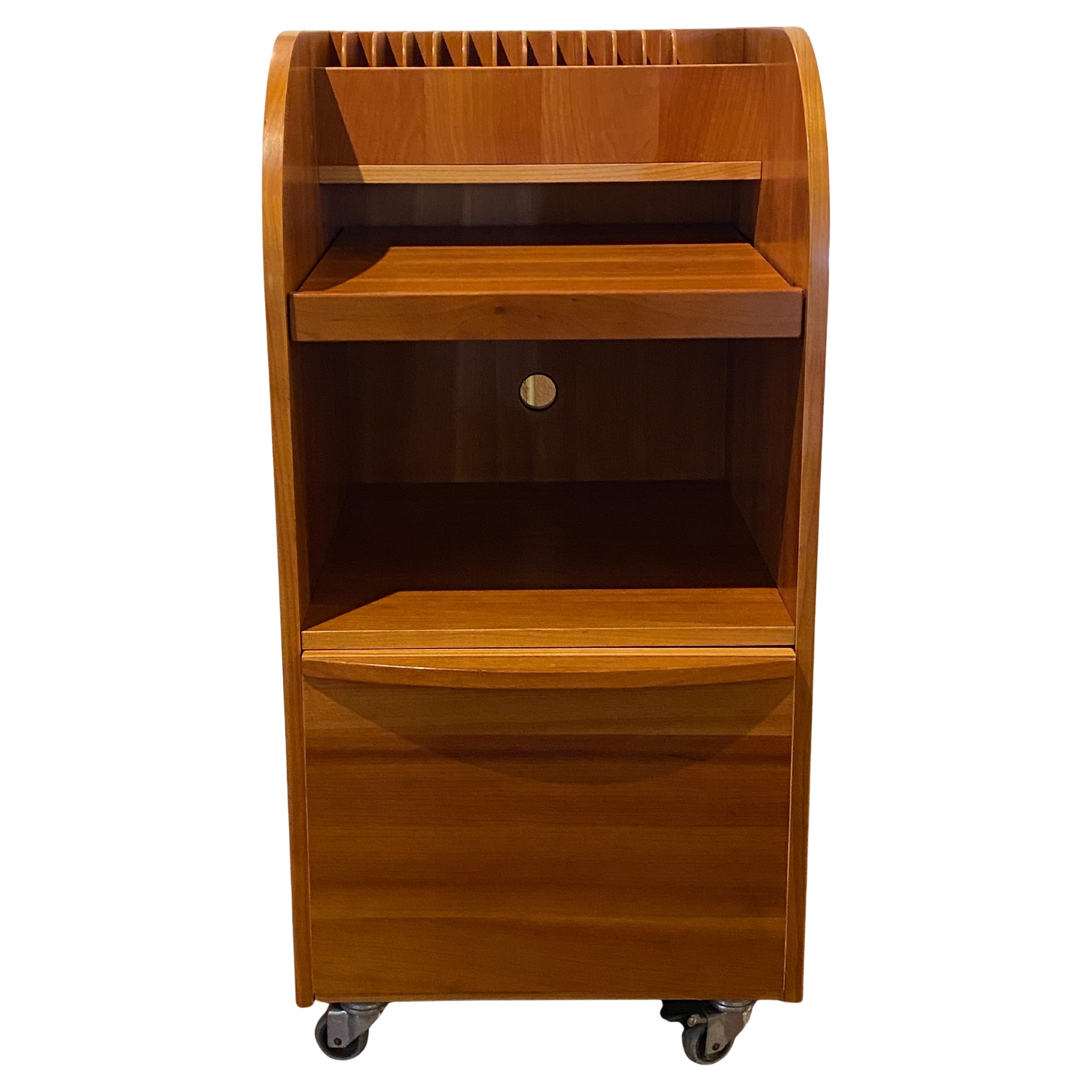 Questo schedario in noce di metà secolo unisce funzionalità e design senza tempo. La sezione superiore è dotata di divisori, ideali per organizzare documenti o file, mentre i ripiani aperti al centro offrono spazio per libri o materiali. Un grande