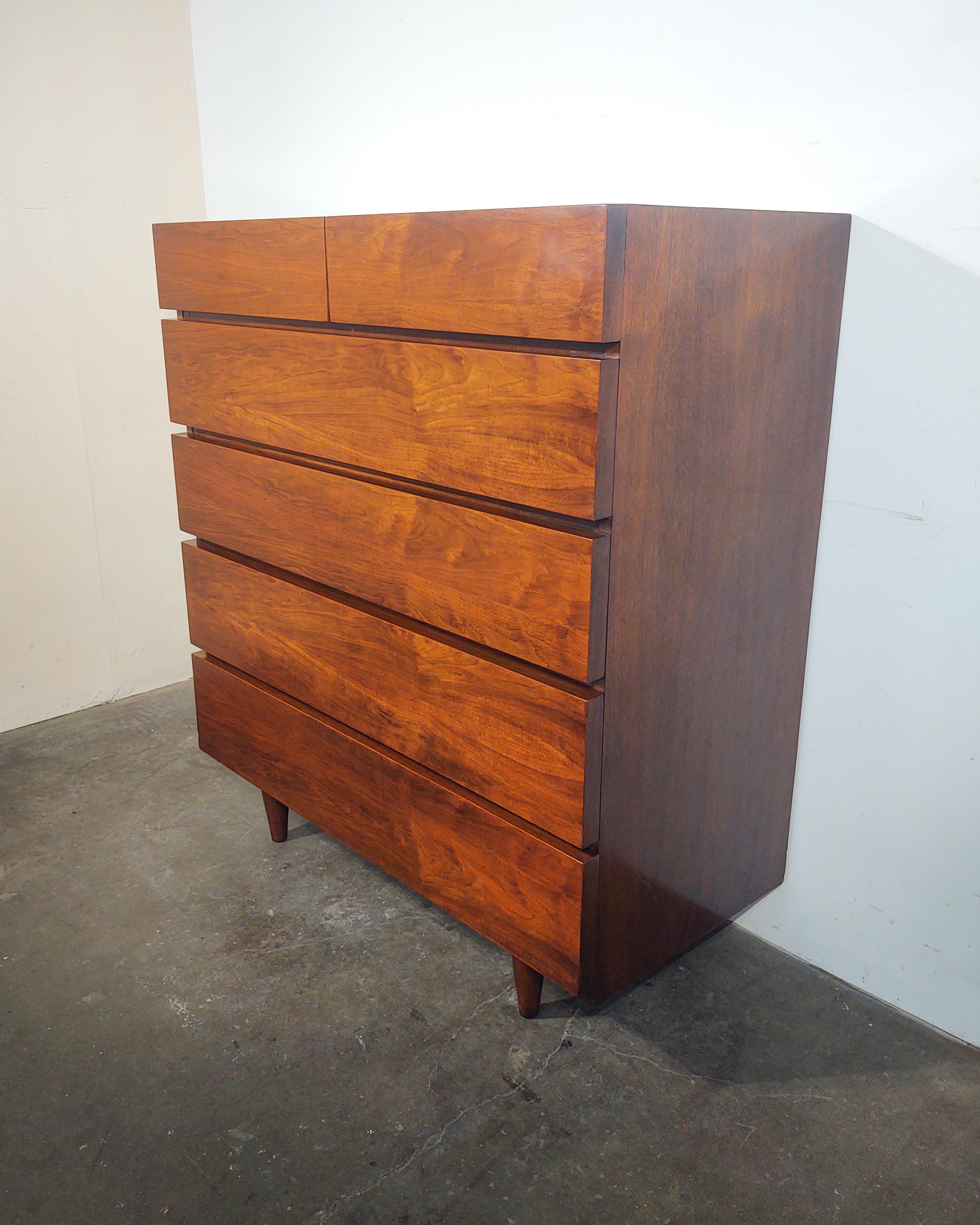 Minimal walnut highboy dresser by American of Martinsville circa 1960s. Gorgeous walnut wood grain covering entire body, excellent craftsmanship. The top two large drawers have dividers inside. Overall excellent original condition, some light wear