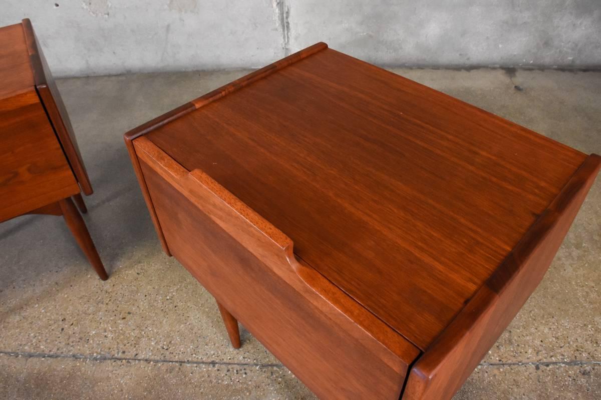 A pair of walnut nightstands from the 'Today' collection designed by John Caldwell for Brown Saltman in 1965. These uncommon pieces feature a distinctive design and very high quality construction utilizing solid walnut and walnut veneer throughout.