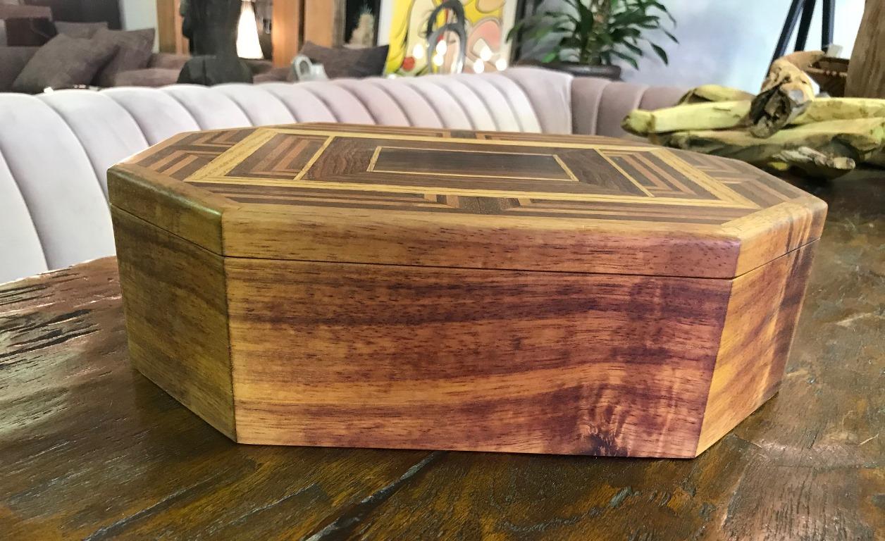Beautiful craftsmanship and design.

This eight sided box is made and inlaid with multiple types of wood including walnut, oak, Koa, mahogany and hinges made of Brazilian rosewood. It has multiple internal compartments. 

Dimensions: 4.25