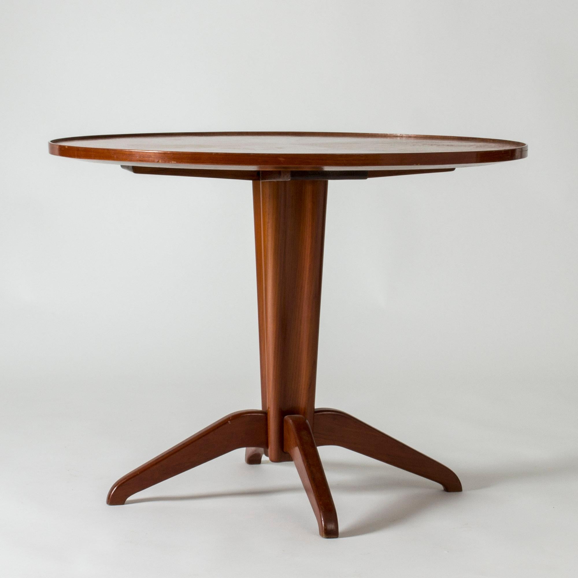 Beautiful round coffee or side table by Oscar Nilsson, in a neat size and a luxurious modernist expression. Warm wood color.