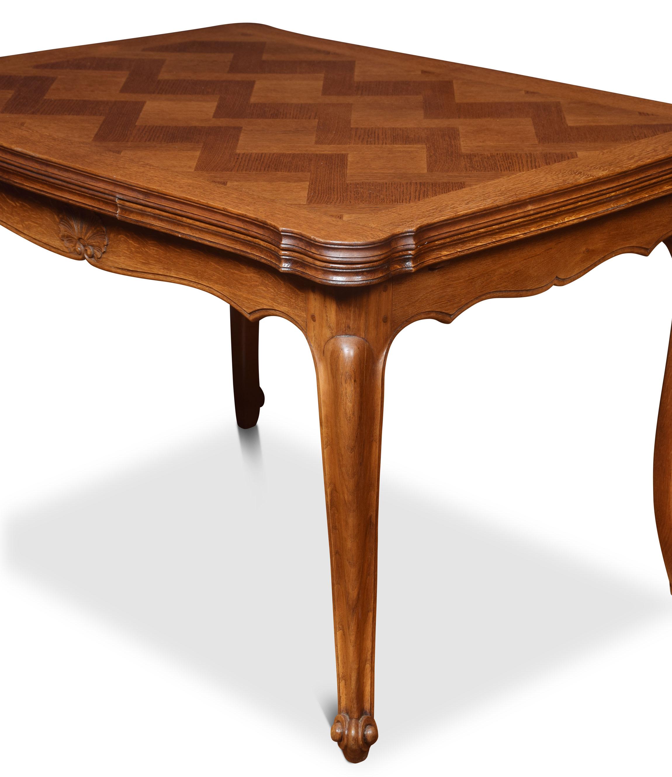French Provincial style draw leaf dining table, the serpentine oak parquet top with two pull out leaves above the shaped carved apron. All raised up on cabriole legs terminating on upswept feet.
Dimensions:
Height 30 inches
Width 47 inches when open