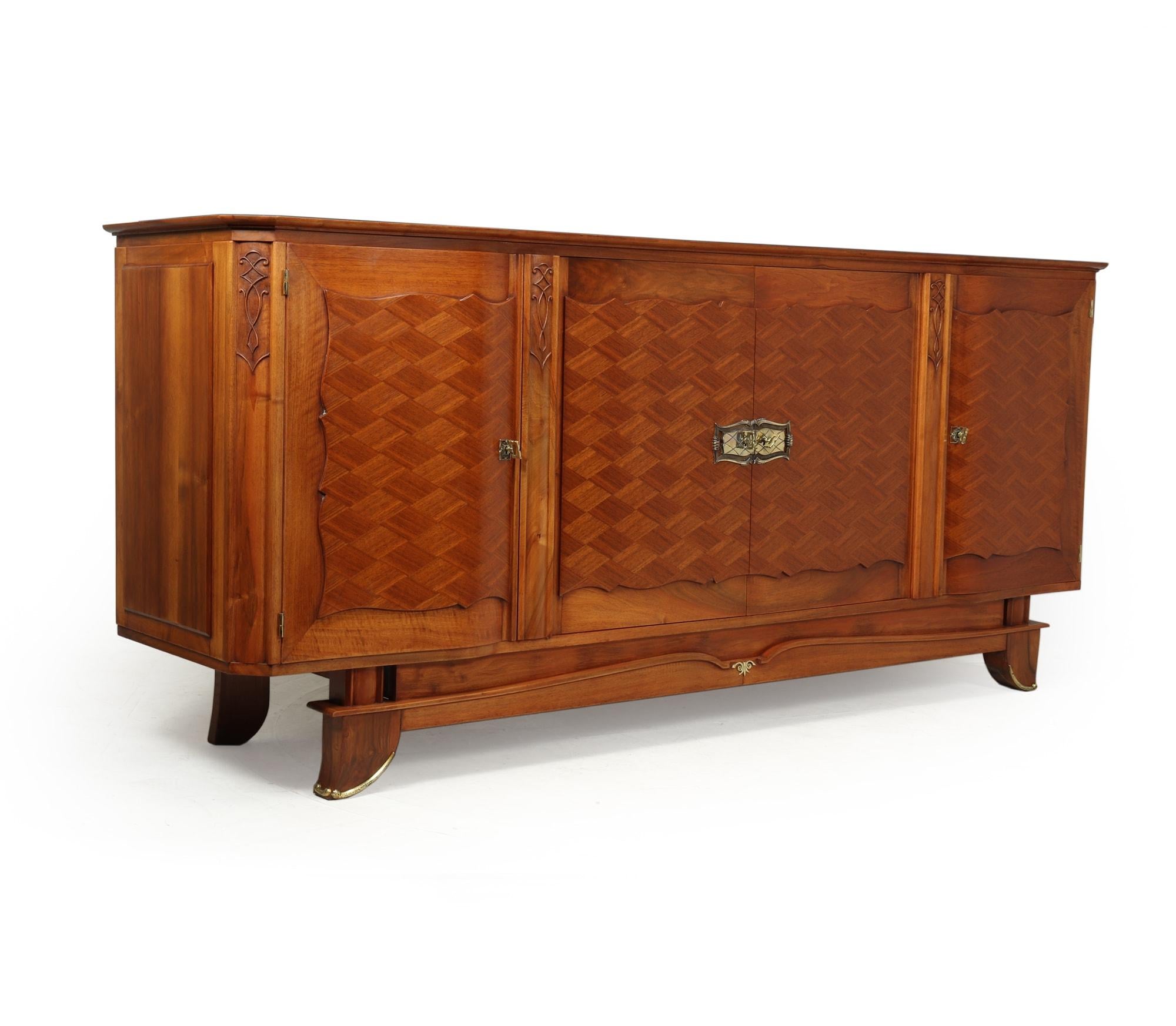 Walnut parquetry sideboard by Jules Leleu c1950
An exceptional quality four door sideboard designed and produced by Jules Leleu in the early 1950s in Paris France, the sideboard is of solid walnut with walnut parquetry inlay with gilt metal mounts