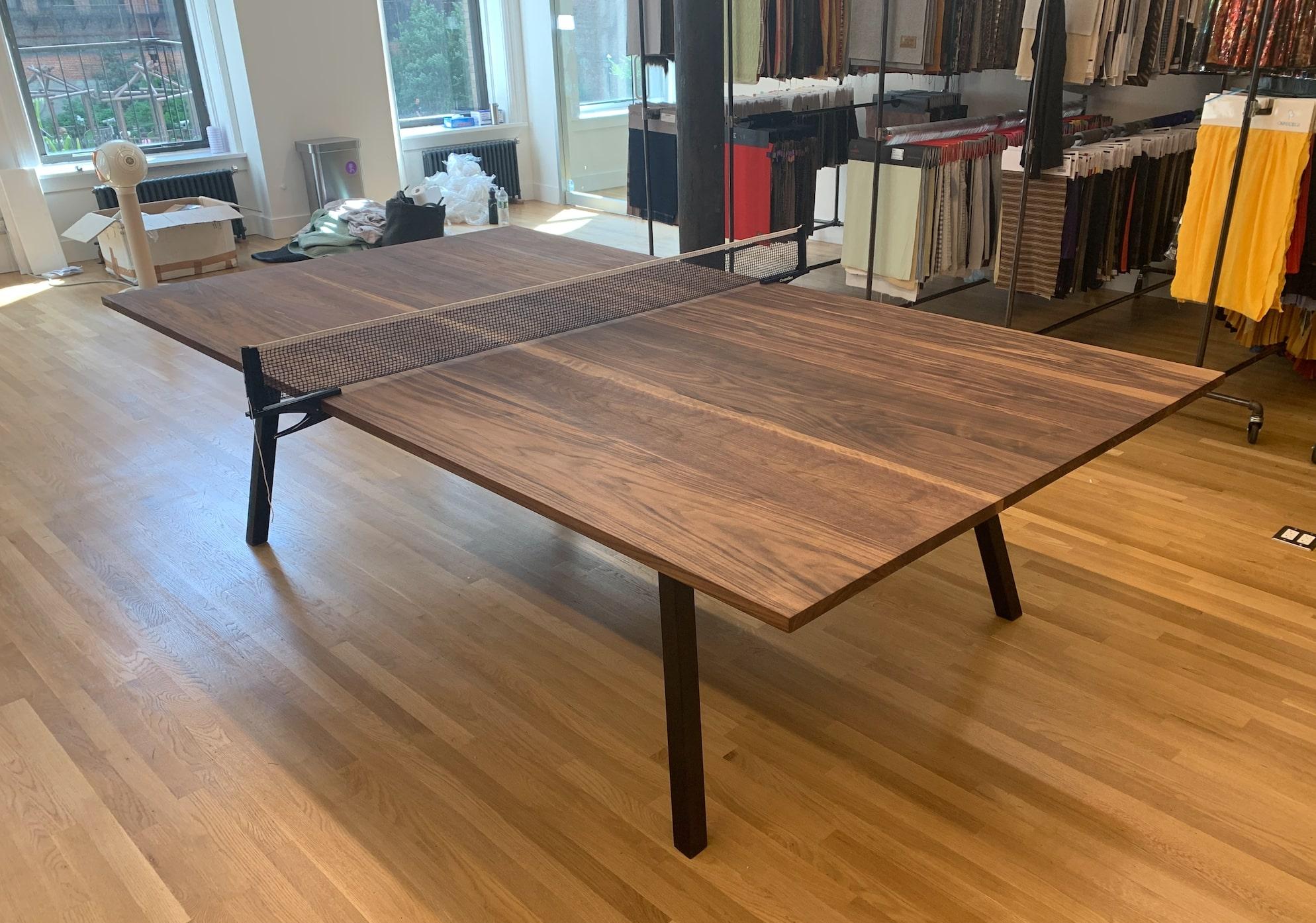 Handcrafted, walnut ping pong table. The solid tabletop rest upon a sleek hidden blackened steel base. The clean lines of this piece exude a Minimalist style that is very appealing in any modern setting while creating a ping pong playing surface for