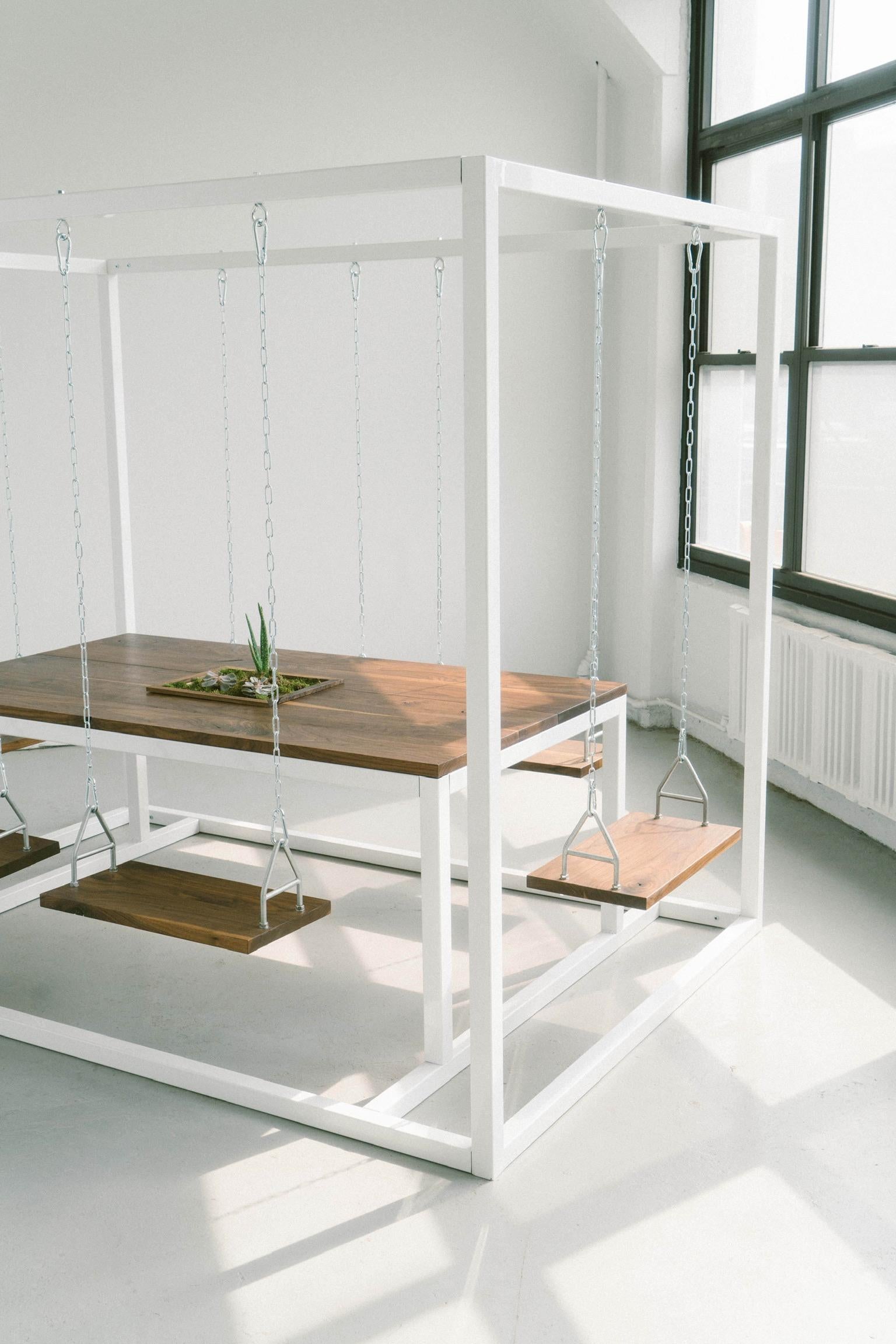 Introduisez un élément d'élégance et d'innovation dans votre espace avec notre SwingTable 6 places. La structure en acier thermolaqué blanc brillant contraste magnifiquement avec le riche plateau de table en dalles de noyer, créant ainsi un impact