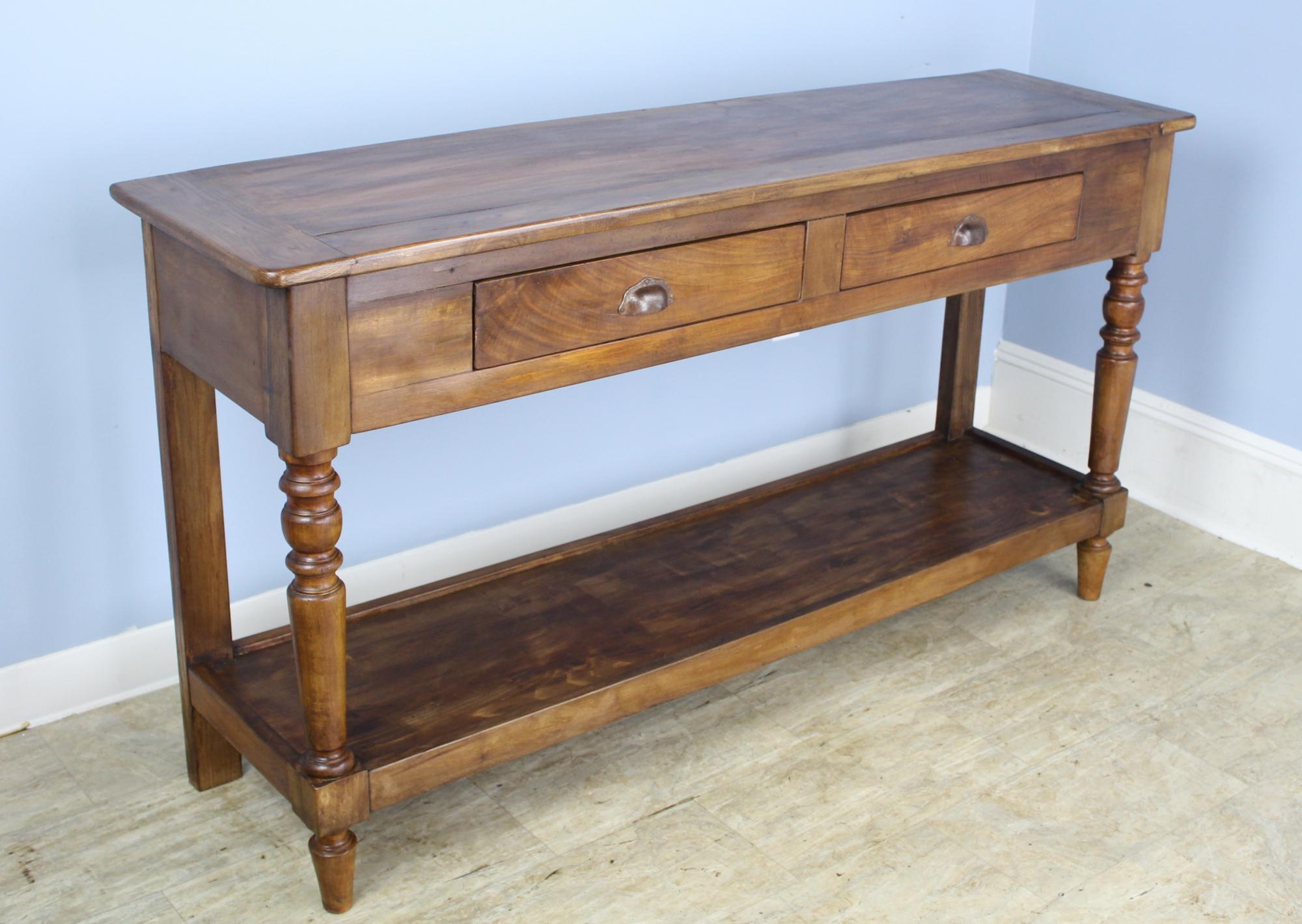 A lovely walnut potboard server, custom made for Briggs House in France with old legs, circa 1850. Generously proportioned with a thick top, two roomy drawers, and vivid walnut color.