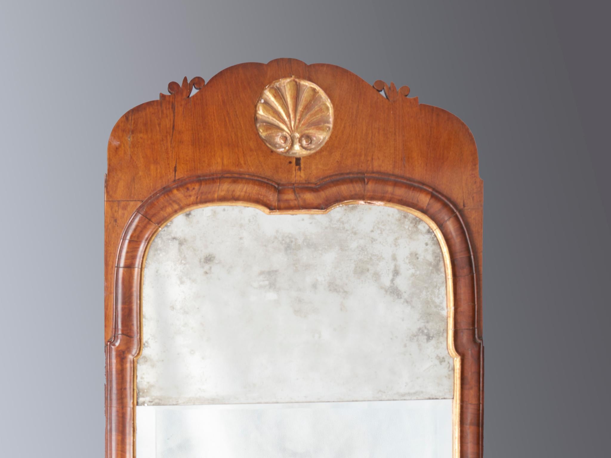 Queen Anne mirror with carved and gilded shell. 2 part glass. English, circa 1740-1750.