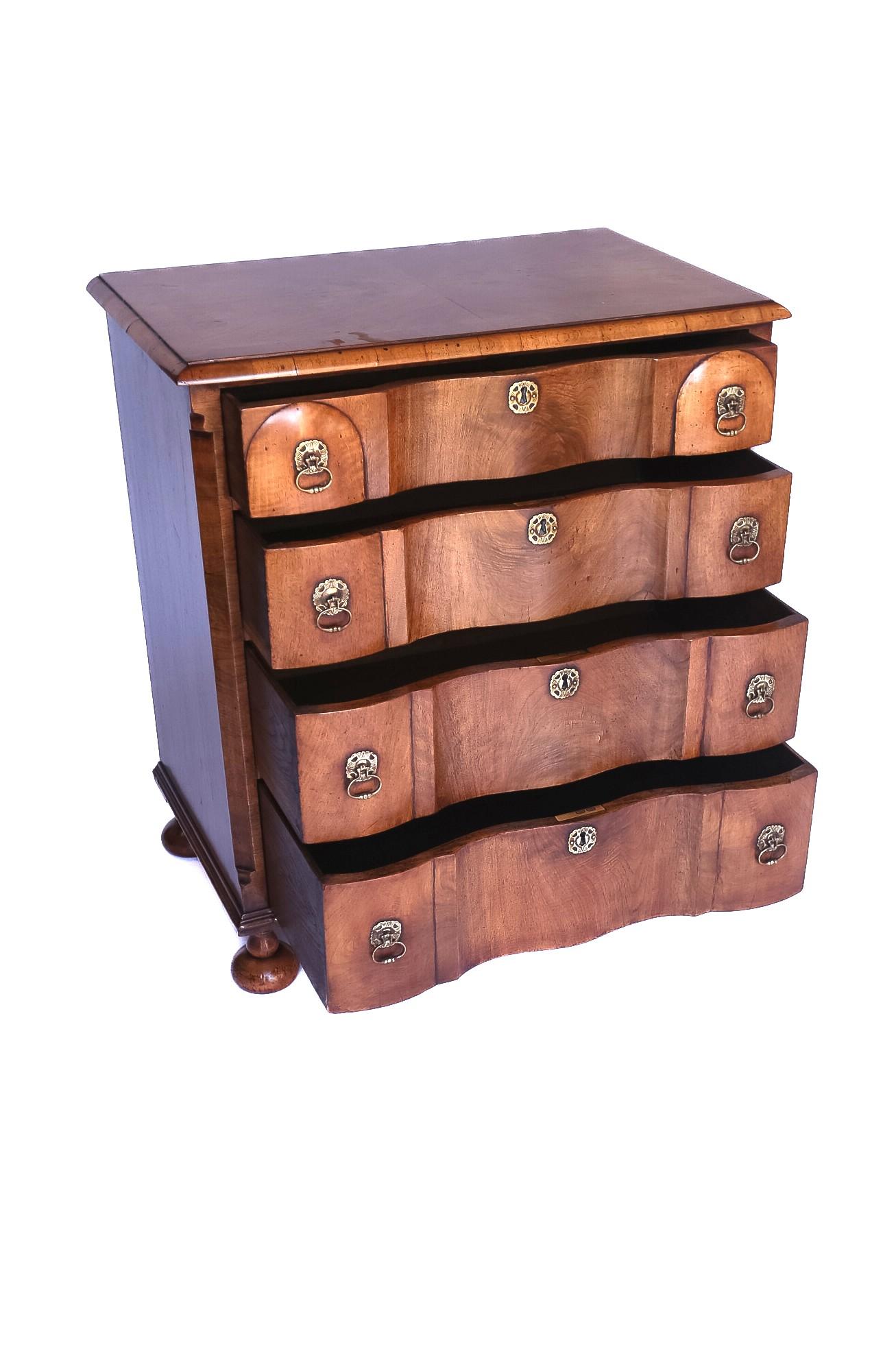 Arcón de 4 cajones de nogal estilo Queen Anne circa años 20
Tablero de chapa de madera de nogal, con bandas transversales de nogal
Frente perfilado 4 cajones, con revestimiento de roble, 
Tiradores de latón de época
Asiento sobre 4 pies de bola de