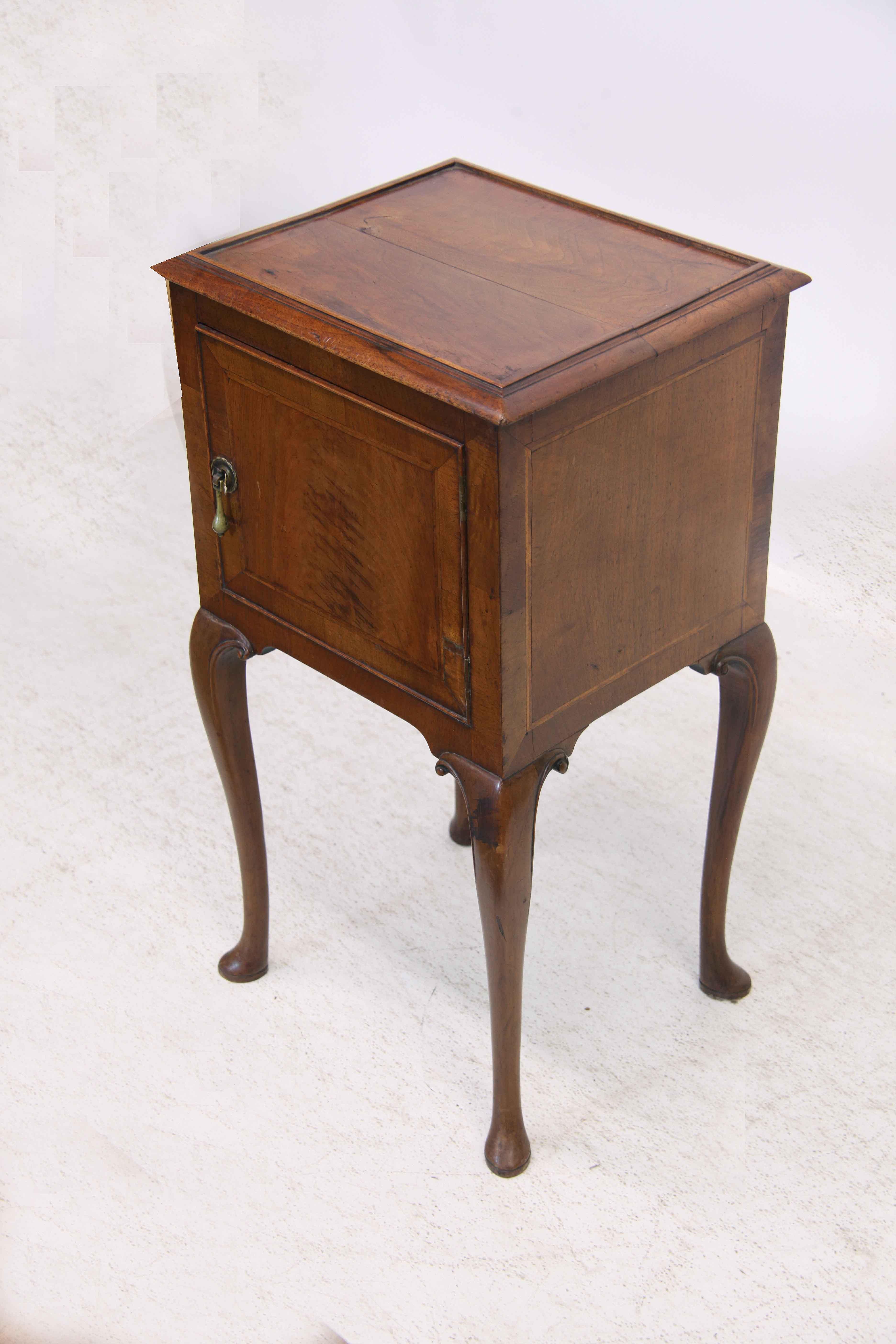 Walnut Queen Anne style side table, the top with molded edge, the door with beautiful walnut veneer and inlaid with a ''herring bone'' style inlay and cross banding around the perimeter, original brass tear drop pull. The sides are similarly inlaid