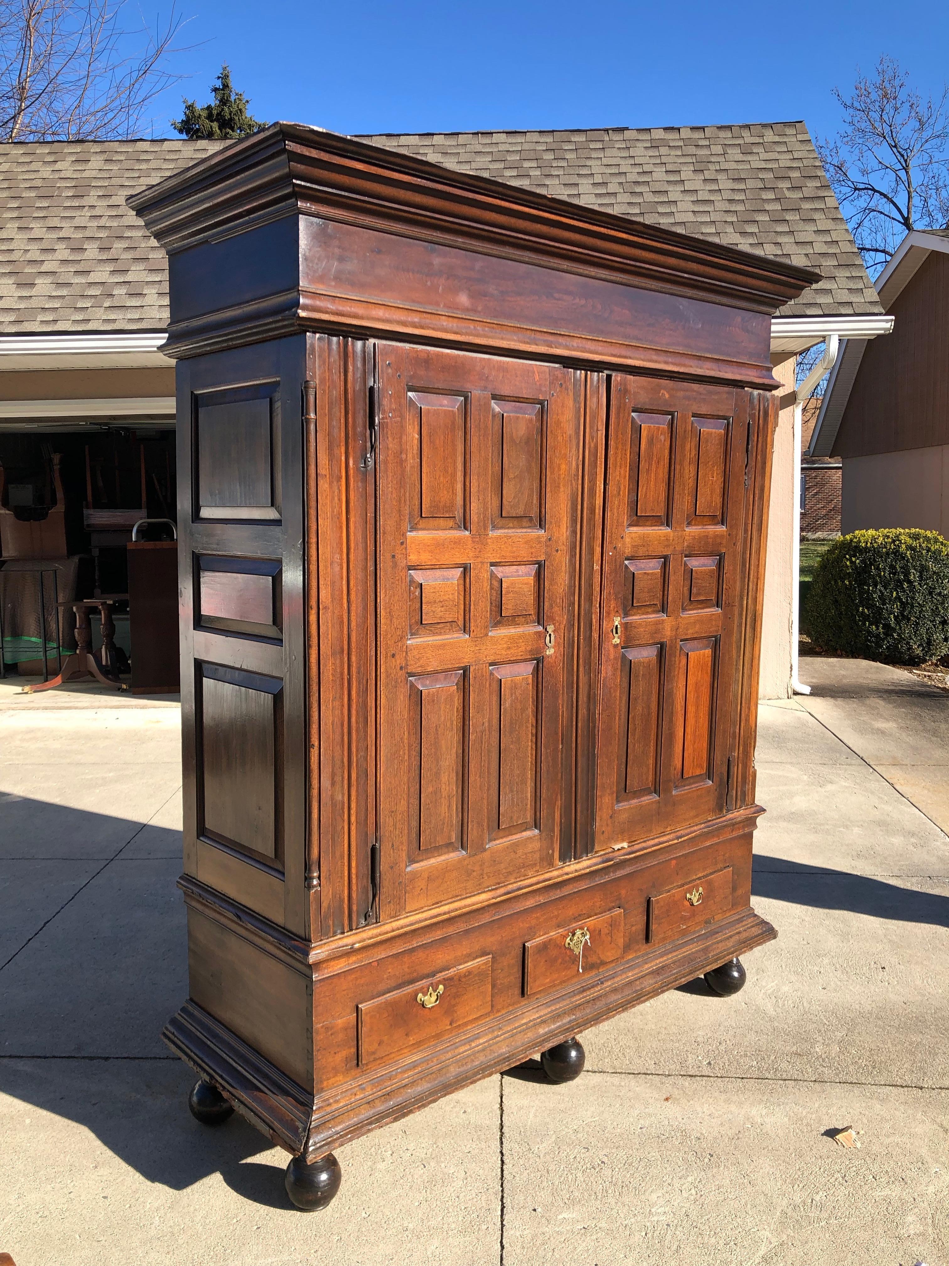 Lancaster County, Pennsylvania walnut schrank, circa 1770, the molded cornice above two doors, each with six raised panels and rattail hinges flanked by linen fold pilasters and raised panel sides above three drawers and molded base, the interior