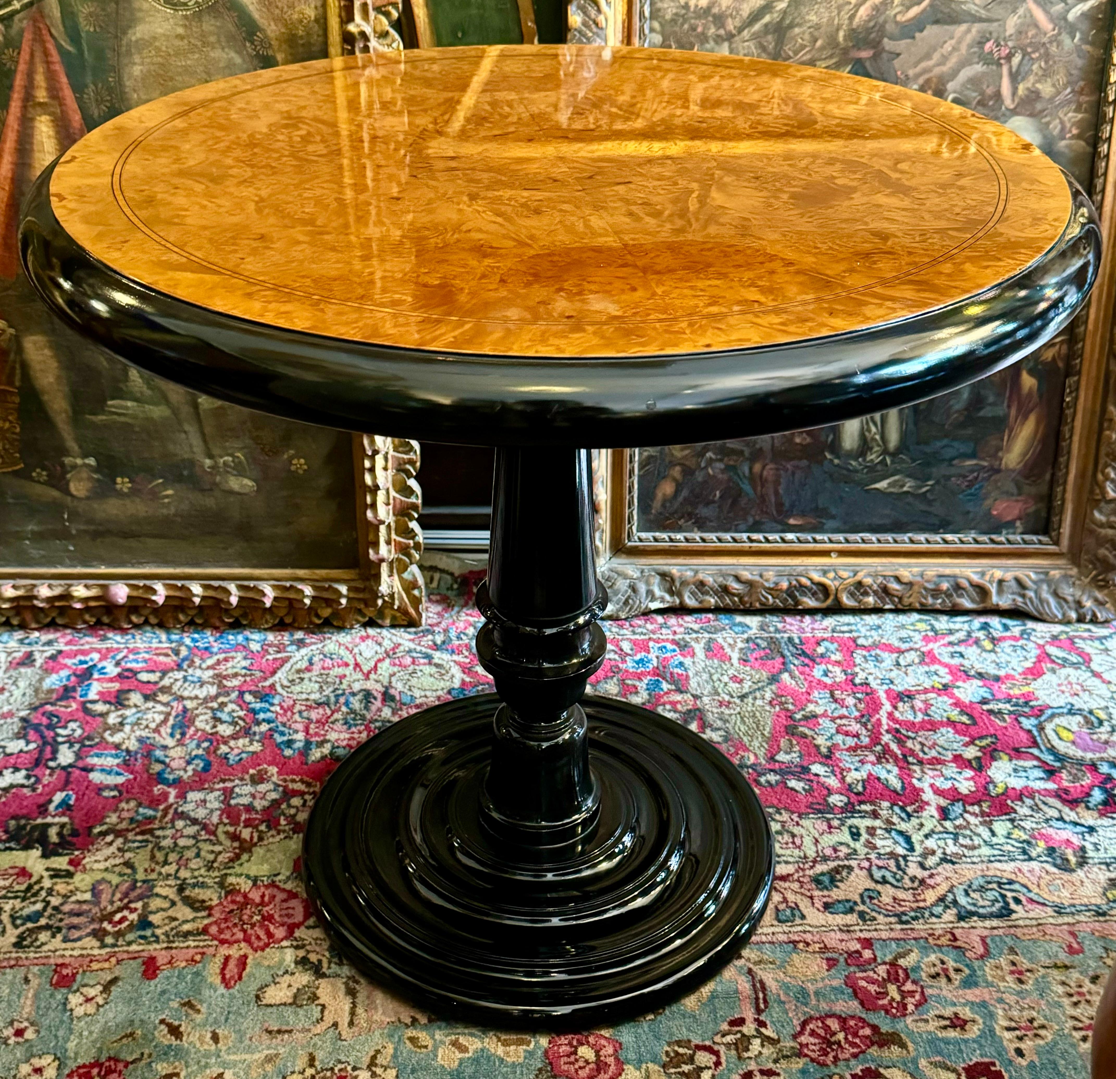 This Art Deco style side table, crafted from walnut root and ebonized wood, exemplifies the sophistication and opulence of early 20th-century design. The table's surface features a striking walnut root veneer, expertly worked using the quartering