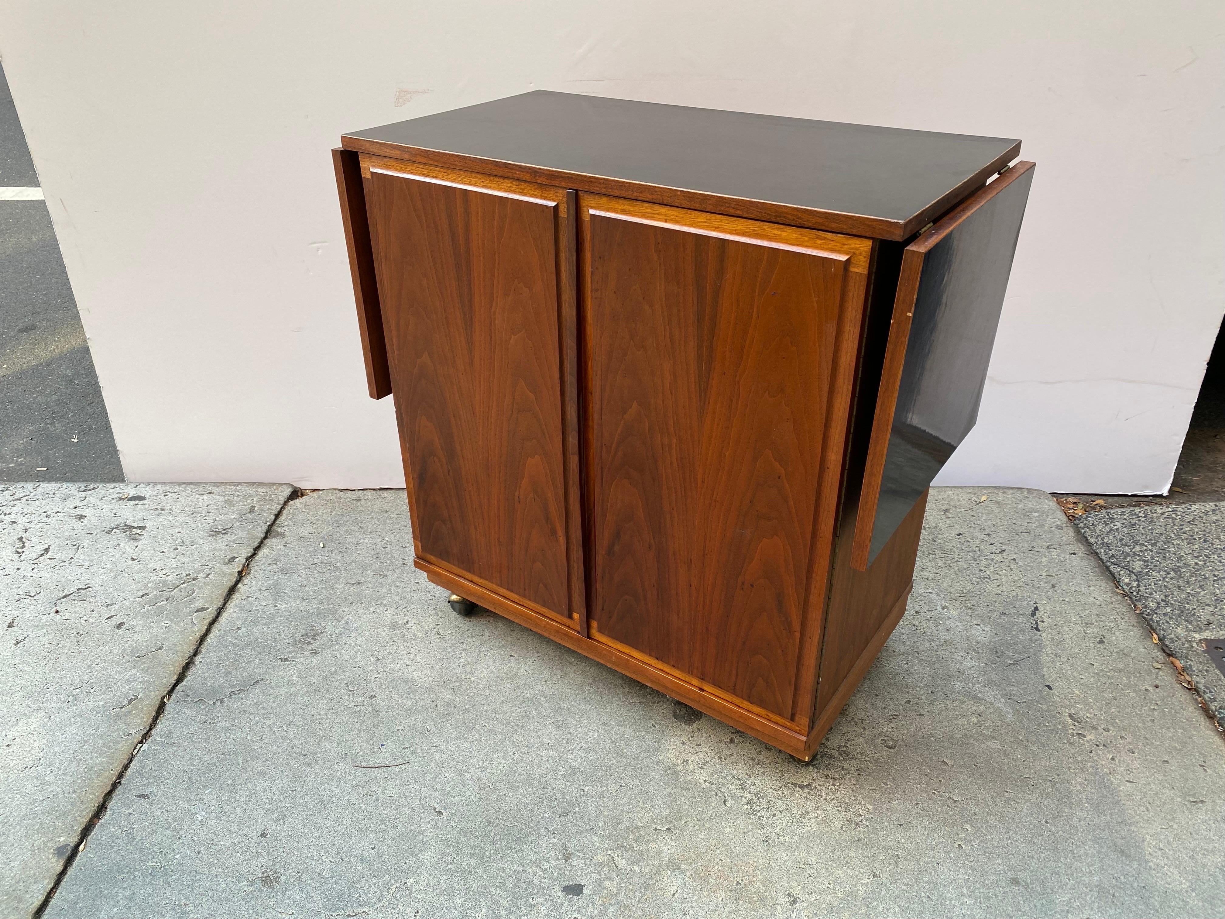 Jack Cartwright for Founders Walnut bar cabinet with 2 pull up leaves that add 16