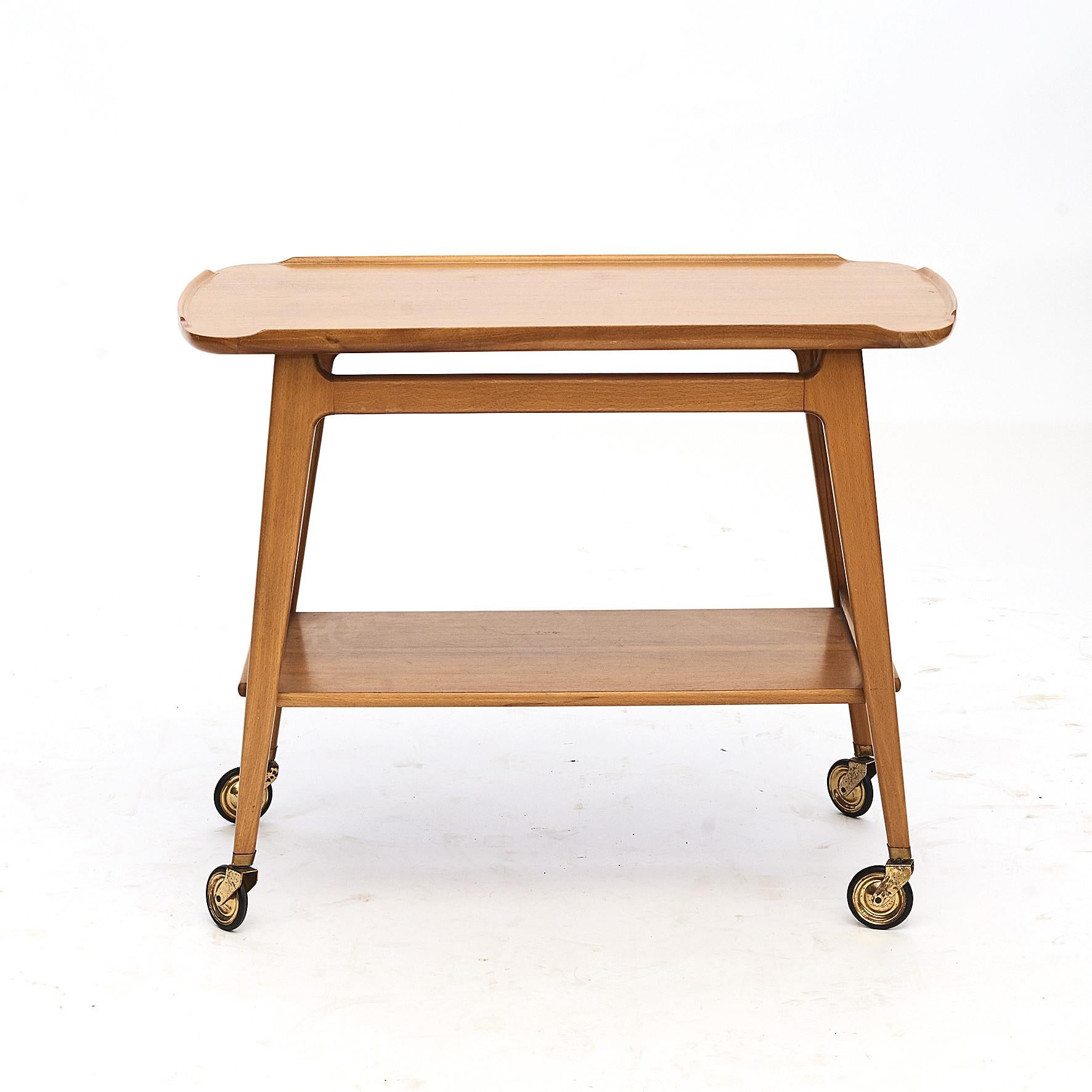 Midcentury serving trolley or bar cart made from walnut and beechwood.
Manufactured by Lotos, Germany, 1960s.