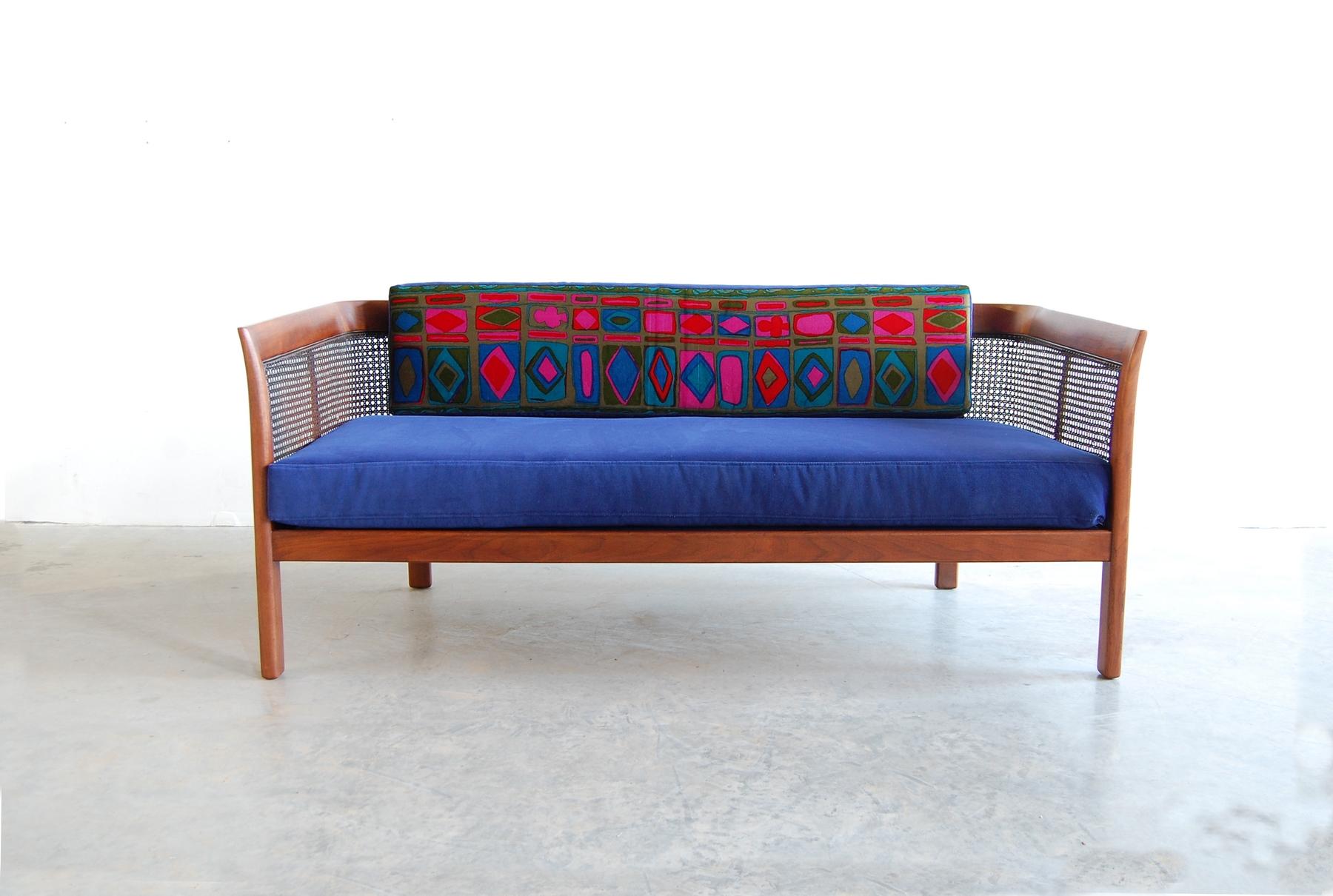Walnut settee with cane back, circa 1966, by Erwin Lambeth. Newly upholstered, we managed to salvage enough of the Jack Lenor Larsen fabric from its original covering to do the face of the back pillow. If you'd like a swatch of the new blue velvet,