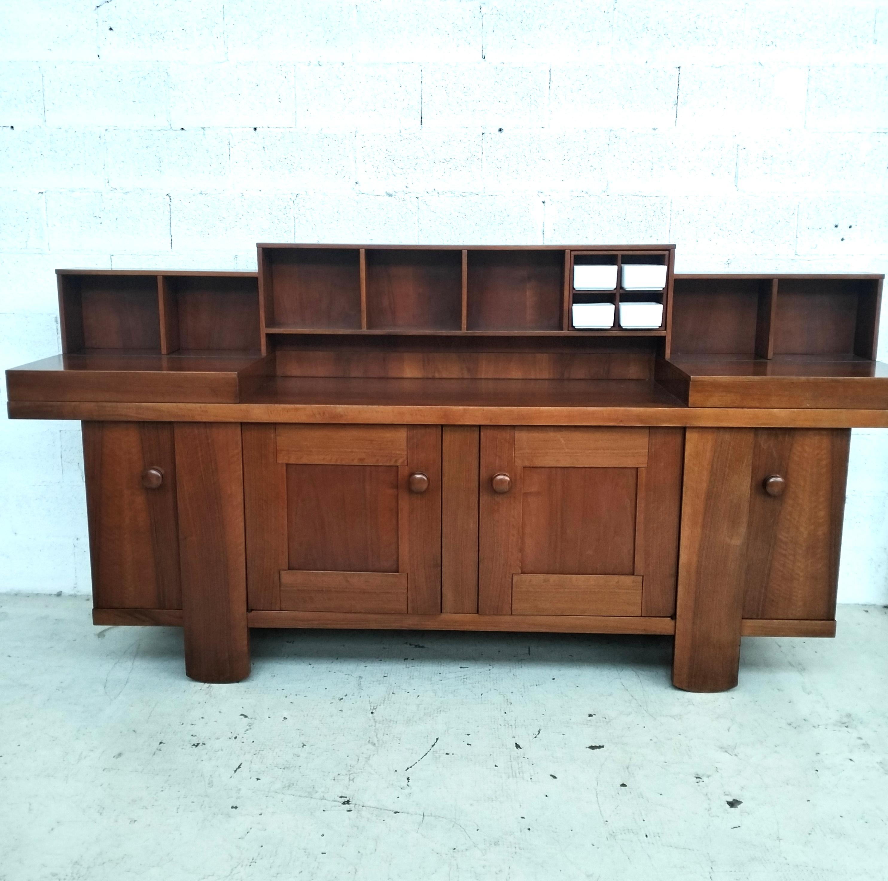 The walnut sideboard, model 602, designed by Silvio Coppola for Bernini in the 1960s–70s, is an iconic piece for lovers of Italian mid-century design — particularly admired for the craftsmanship in walnut wood, featuring aged raised sections and