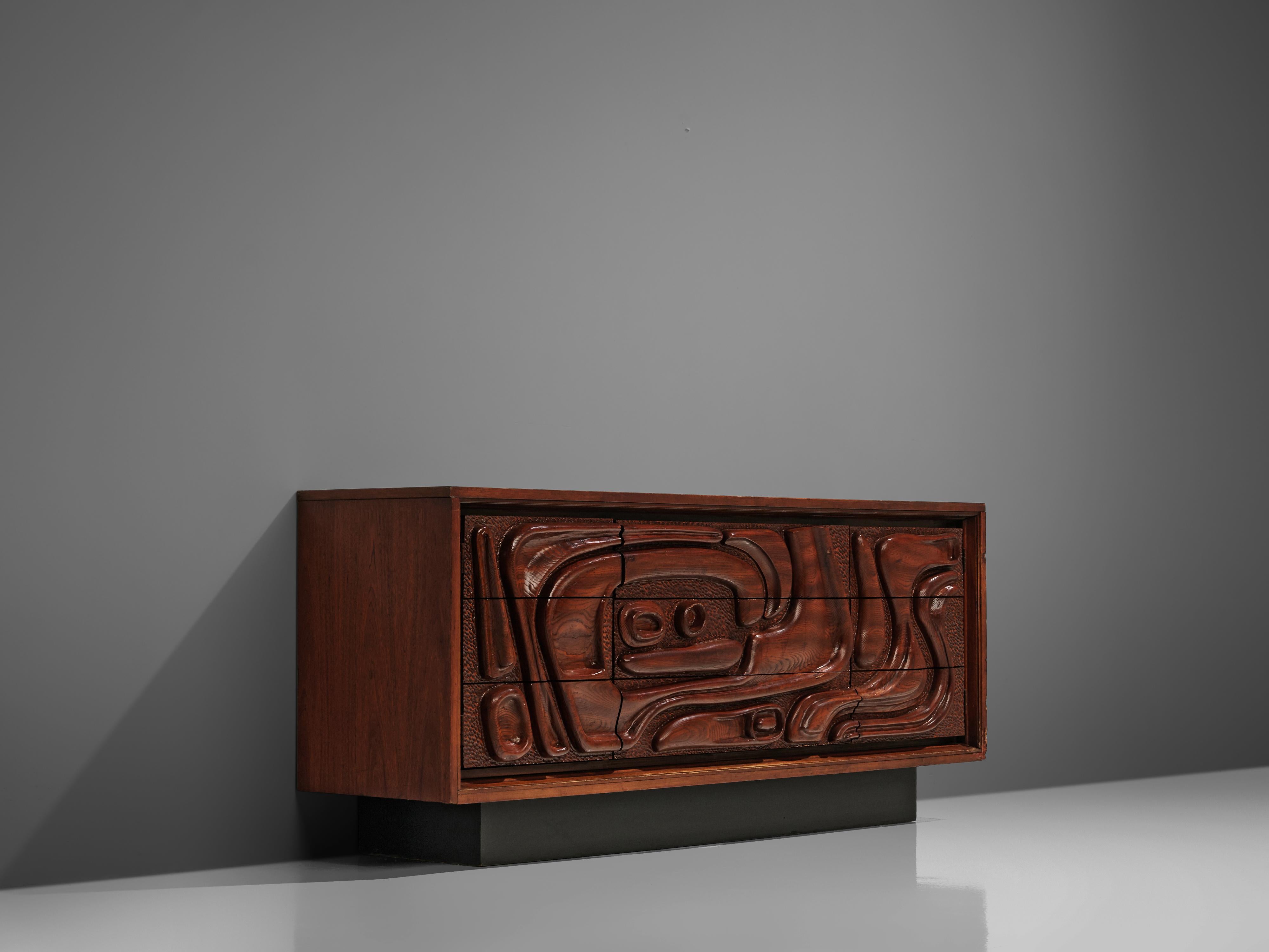 Pulaski Furniture Corporation, sideboard, walnut, facade, United States, 1960s

A carved cabinet in walnut by Pulaski Furniture Corporation. The wildly carved front shows an organic, tribal inspired relief. A squares base lifts the sideboard up.