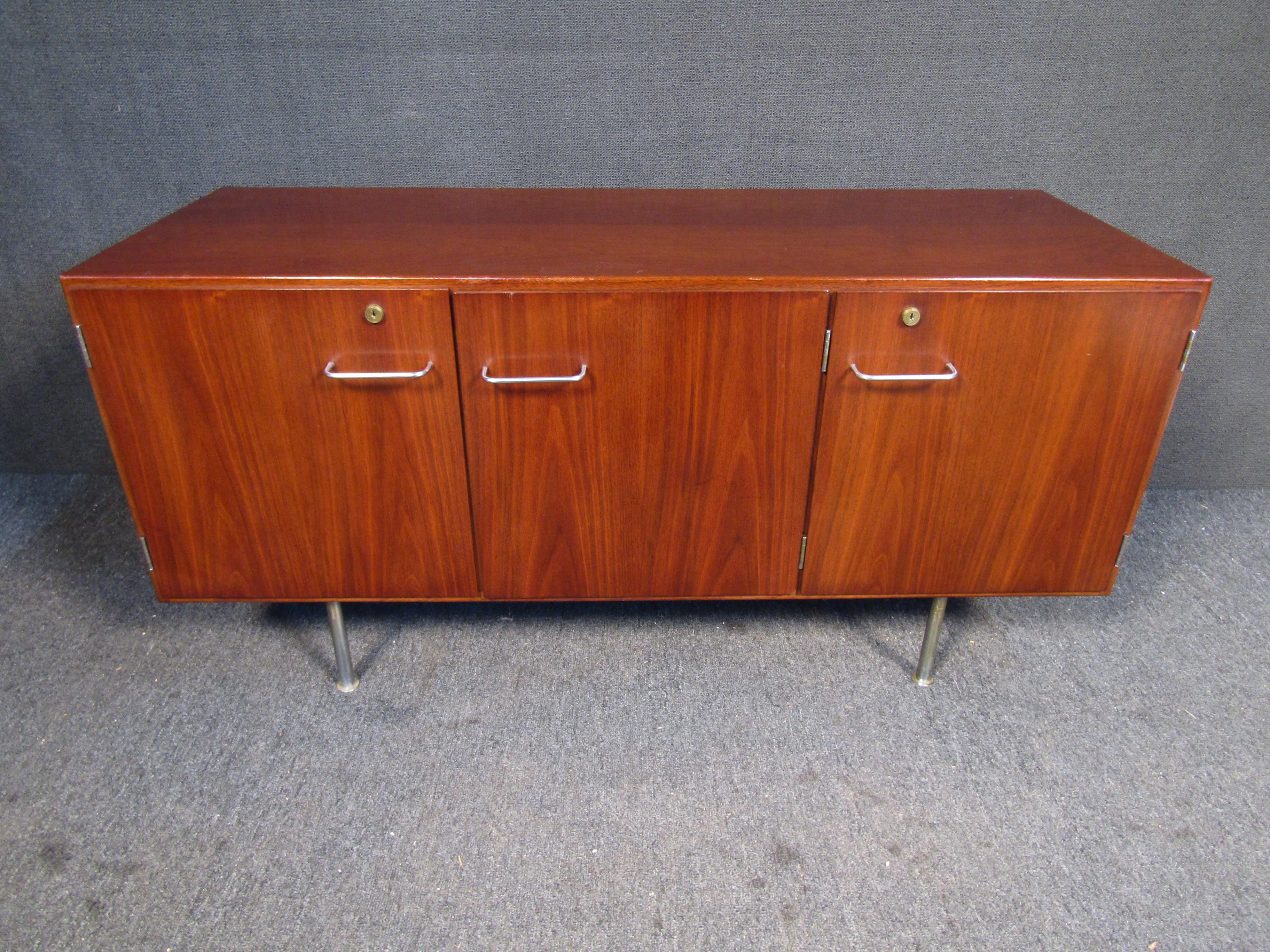 An elegant Mid-Century Modern sideboard with plenty of storage and style. Styled after the designs of Knoll Furniture, this vintage piece combines walnut wood with metal accents and legs. Please confirm item location with seller (NY/NJ).