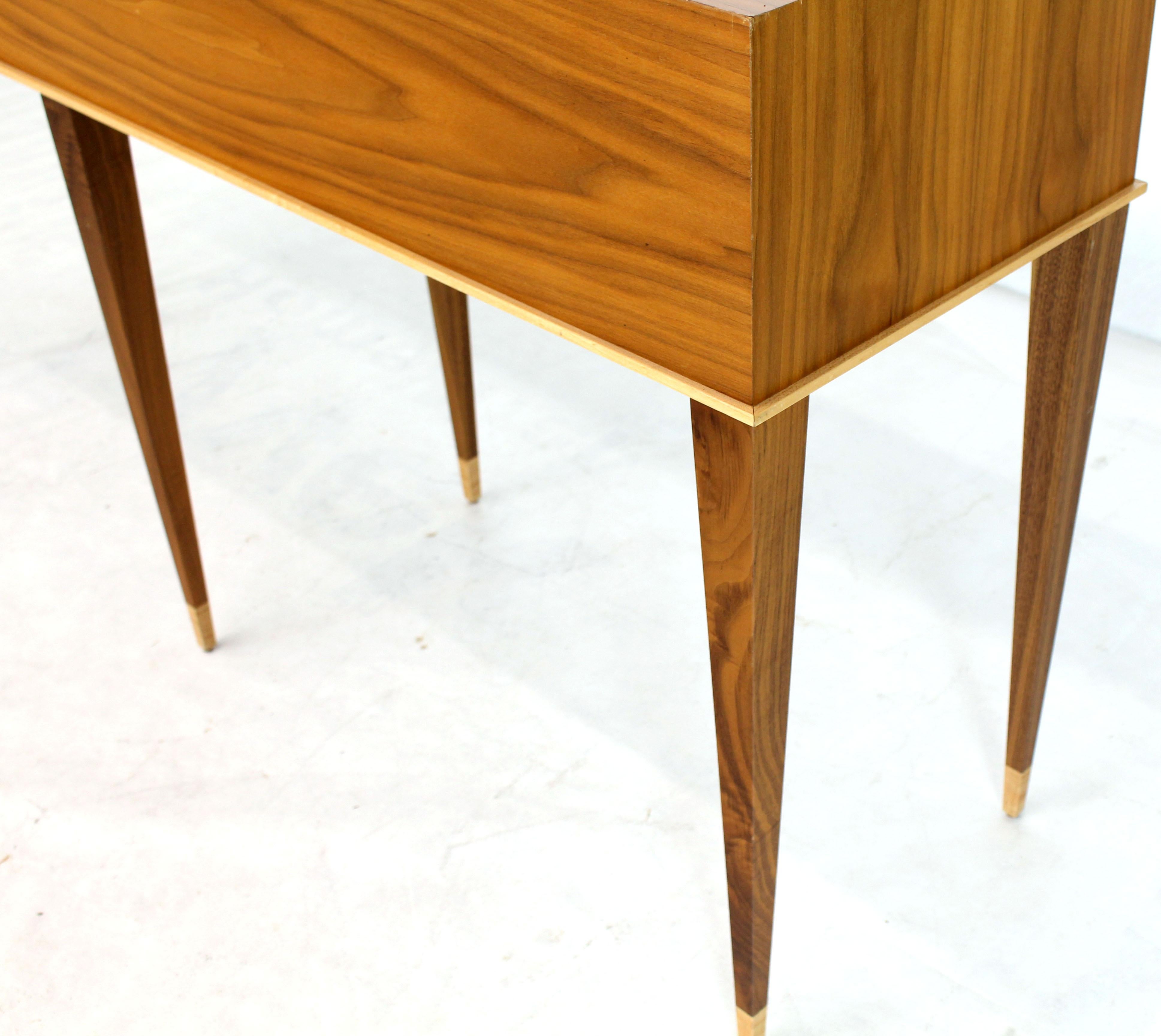 Mid-Century Modern rectangular walnut console table on six tapered legs with higher wood accents.