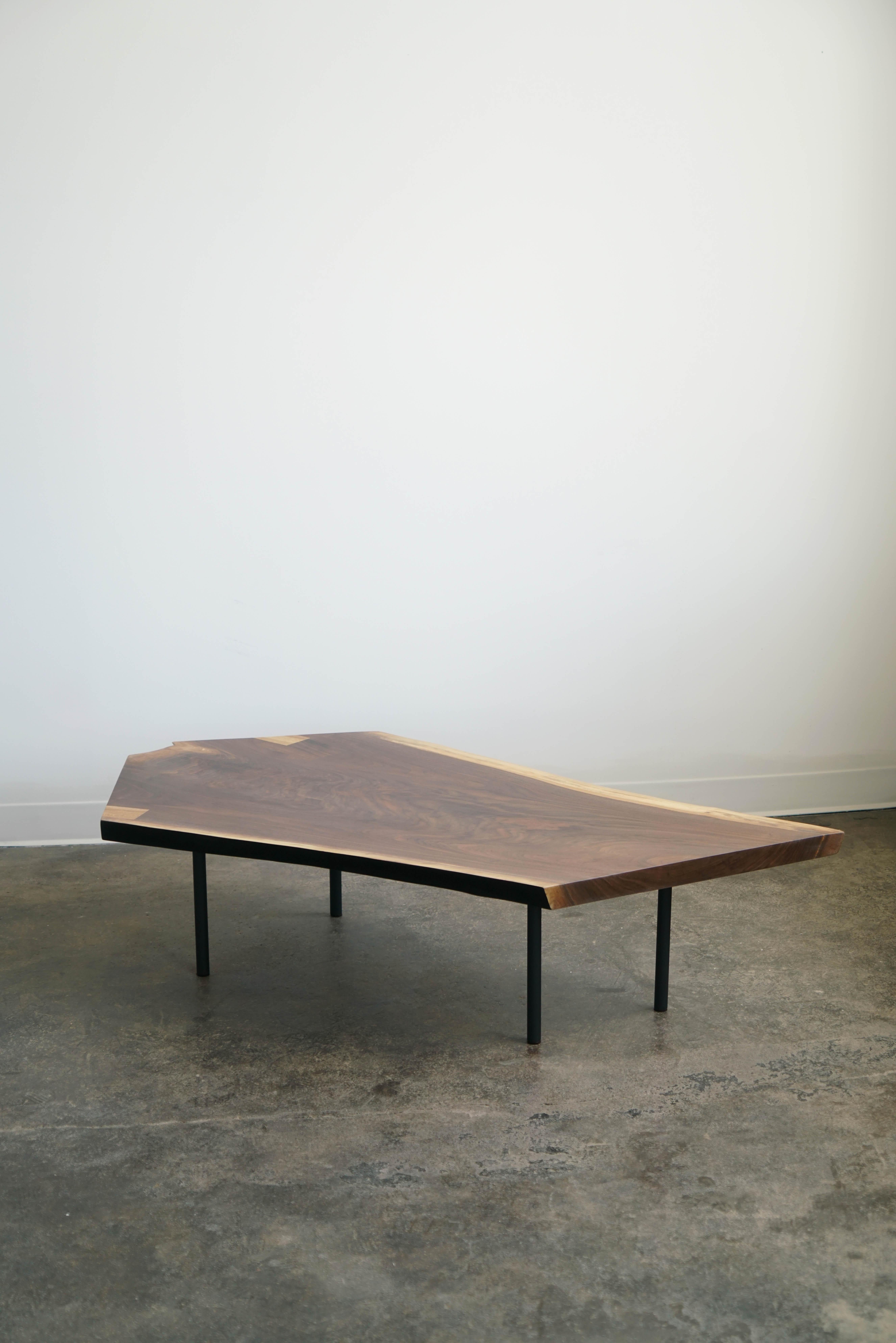 One-off walnut slab coffee table in a natural finish by Last Workshop.

New. Made in 2021 in Chicago, IL. 

Dimensions: 57” x 32” x 14”H

Four black steel legs.
Ebonized edge on two of the sides.