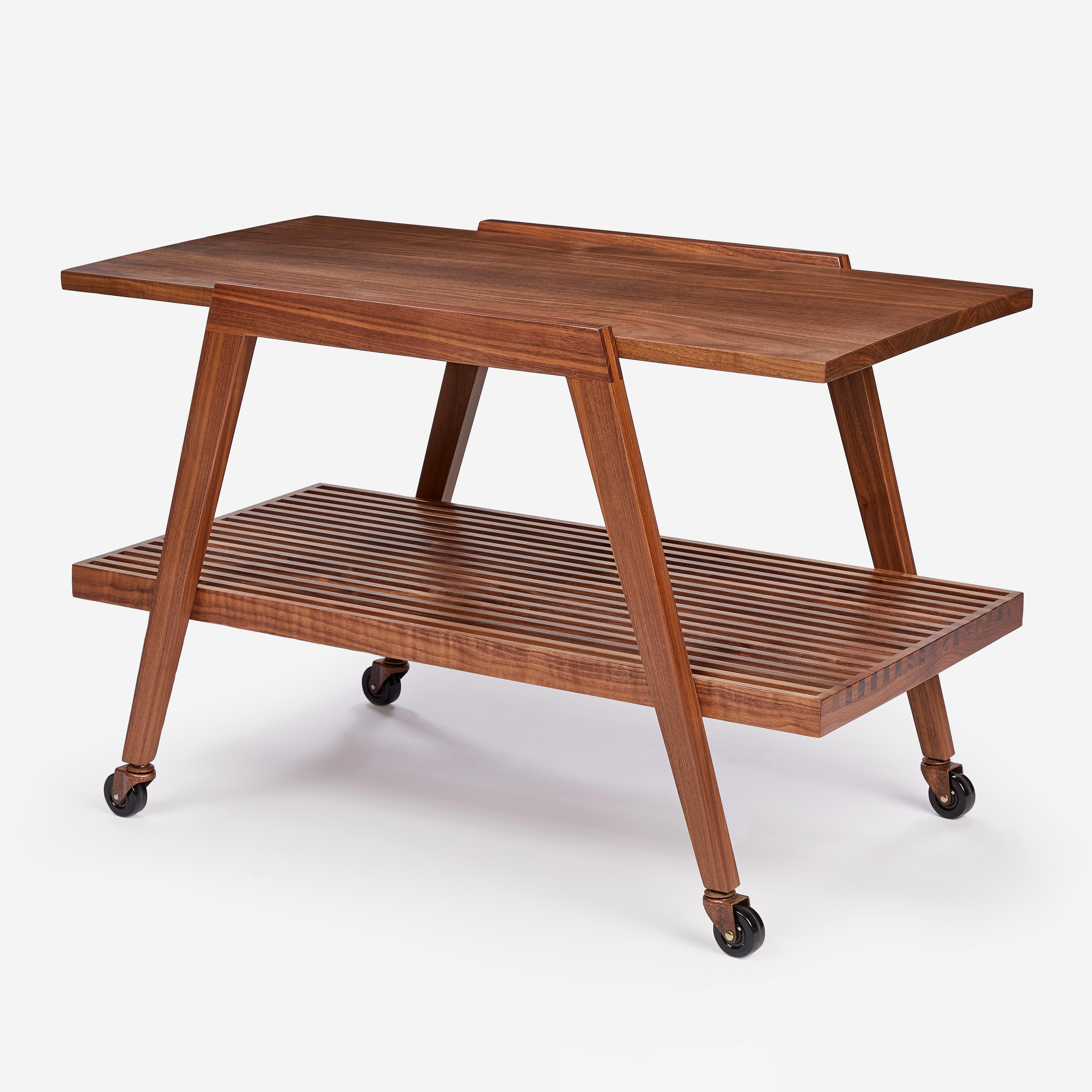 Originally designed by Mel Smilow in 1950 and reintroduced in 2022, the Slatted Tea Cart is a two-level rolling cart built with our signature walnut slats and fine joinery details. The wheels are made of hard rubber and secured with a brass caster.