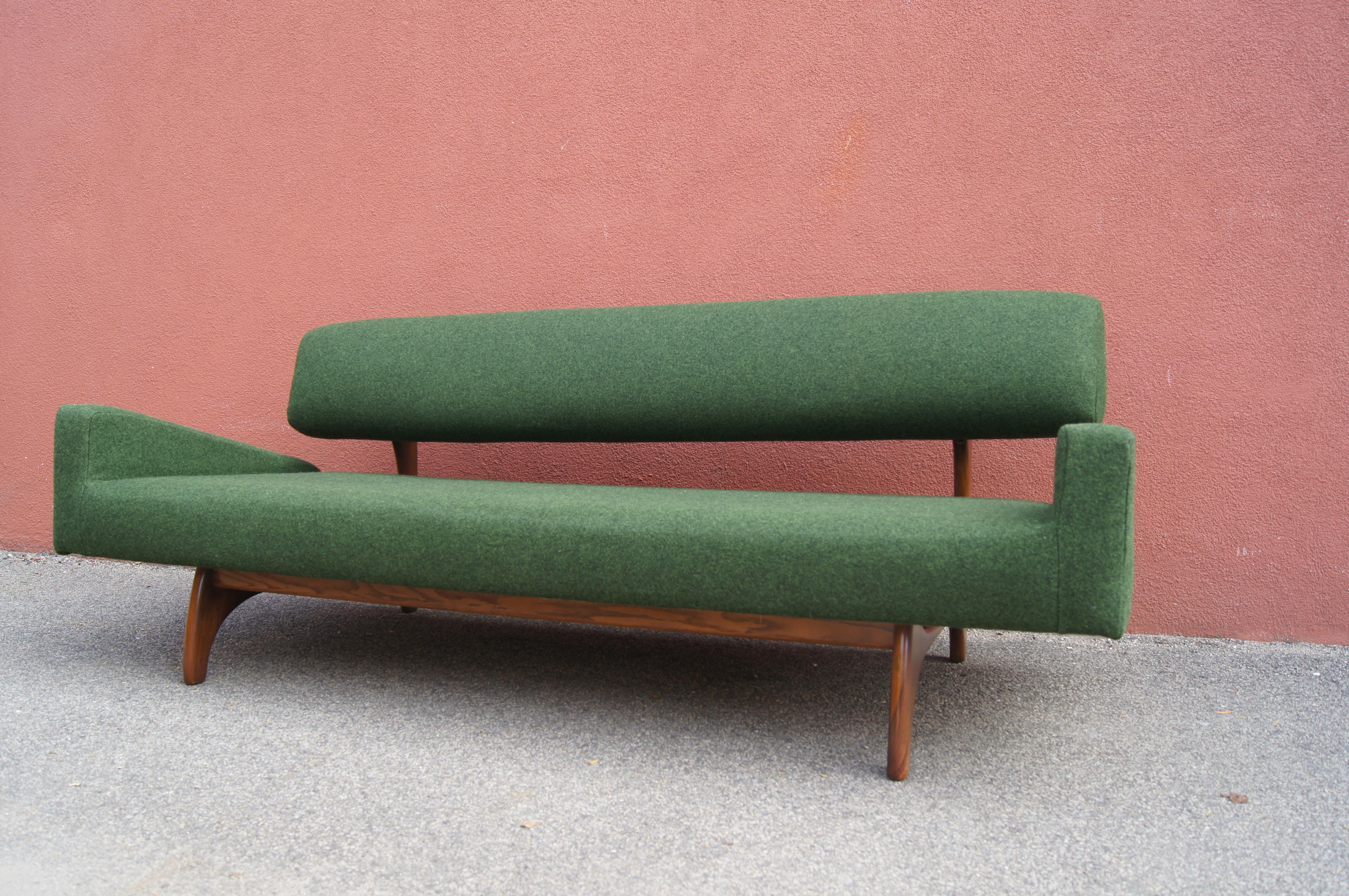 The exuberant lines of Adrian Pearsall's 829-S sofa for Craft Associates make for an eye-catching piece. A walnut frame with gently arced legs brackets a deep seat and bolster-like backrest. The forest green wool felt of the new upholstery (Maharam