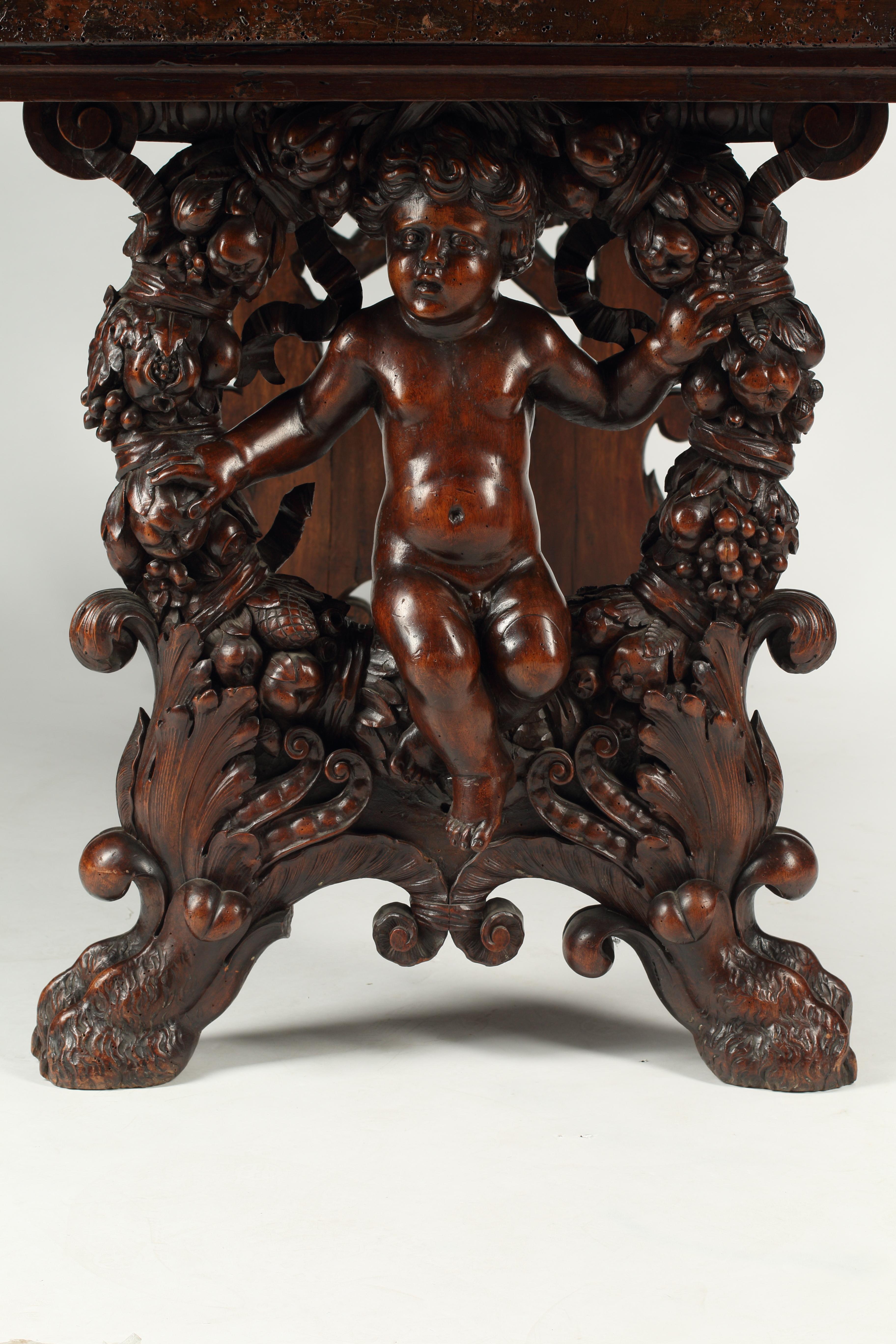 Impressionnante table à tréteaux en noyer finement sculpté de la fin du XVIIIe siècle ou du début du XIXe siècle, avec des puttis inhabituellement sculptés sur les côtés.
La sculpture fait l'objet d'une attention méticuleuse, elle est robuste et