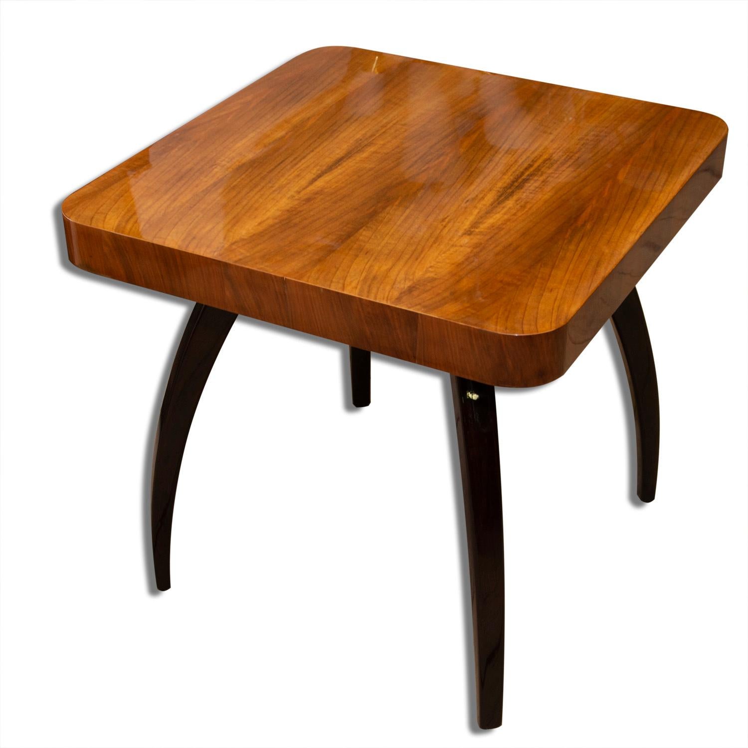 This walnut table called spider was designed by the world famous architect Jindrich Halabala under catalog No. H-259 in the 1930s and produced in the 1950s. Unique style of this table is recognized all-over the world. The table stands on four legs