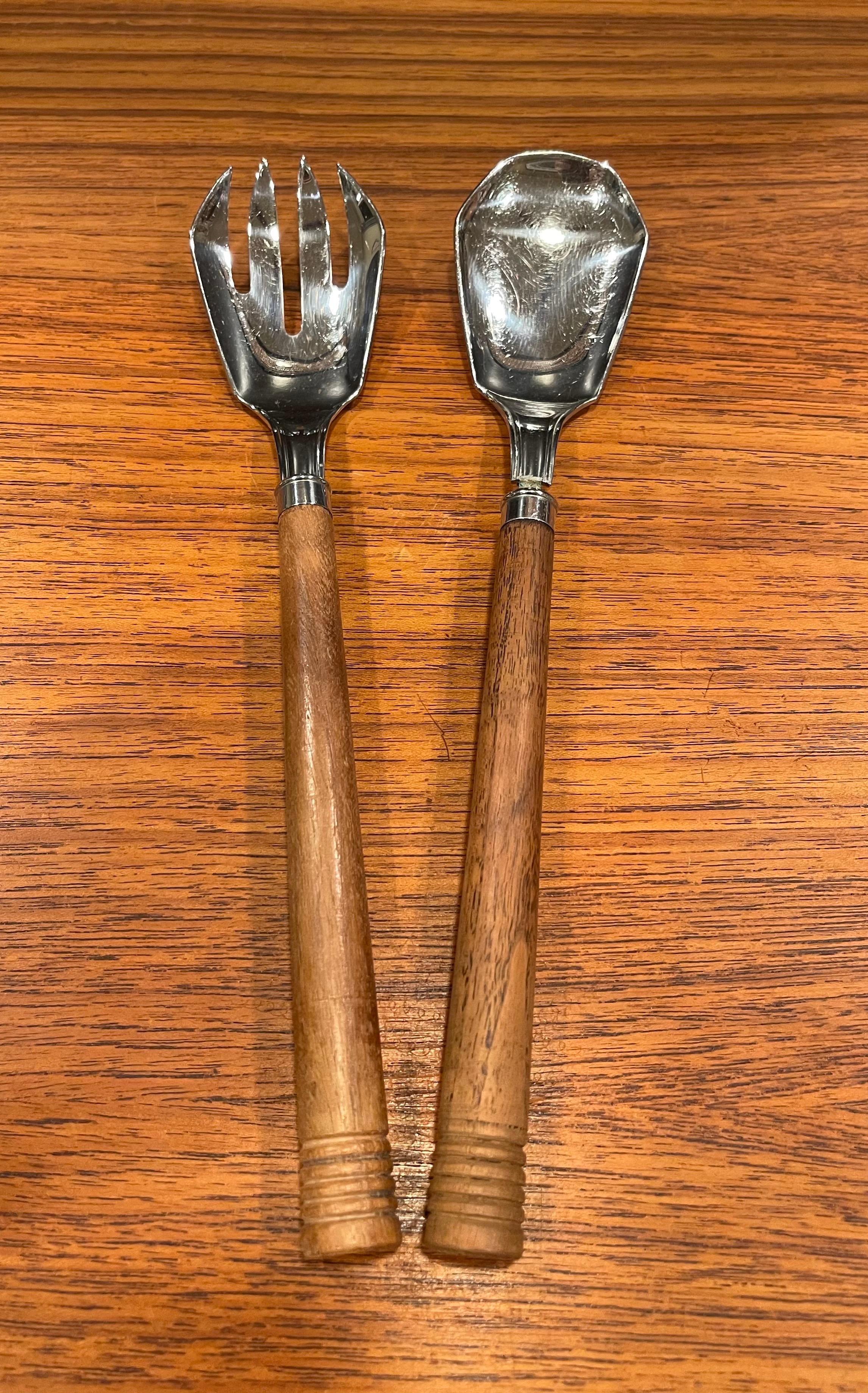 A nice pair of walnut and stainless steel Art Deco salad servers for Chase & Co., circa 1930s. The servers handles are made of solid walnut with the end portions ribbed and they measure 10