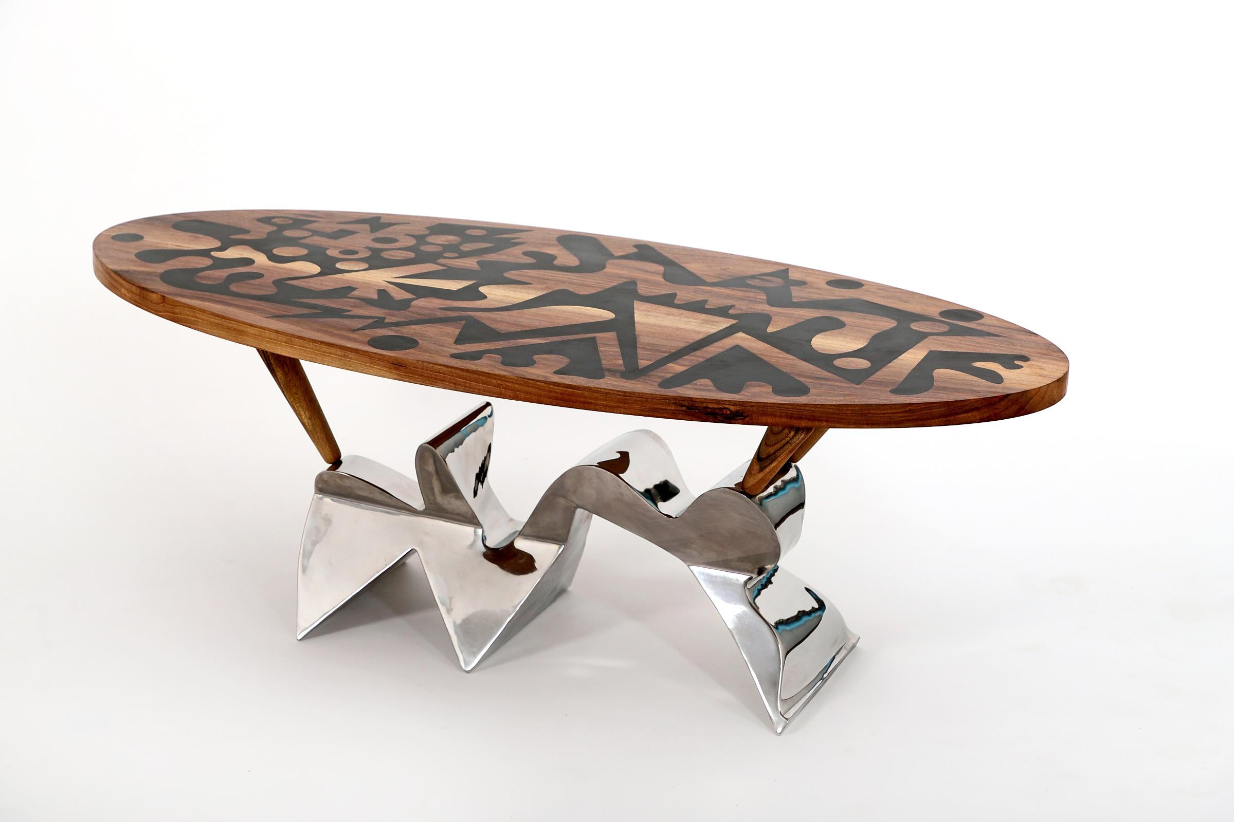 The table top made of walnut wood has hand-carved ornaments that are filled with epoxy resin.
The stainless steel leg was hand welded and then hand polished.
The main idea was to use the epoxy resin casting system in an interesting way.
 