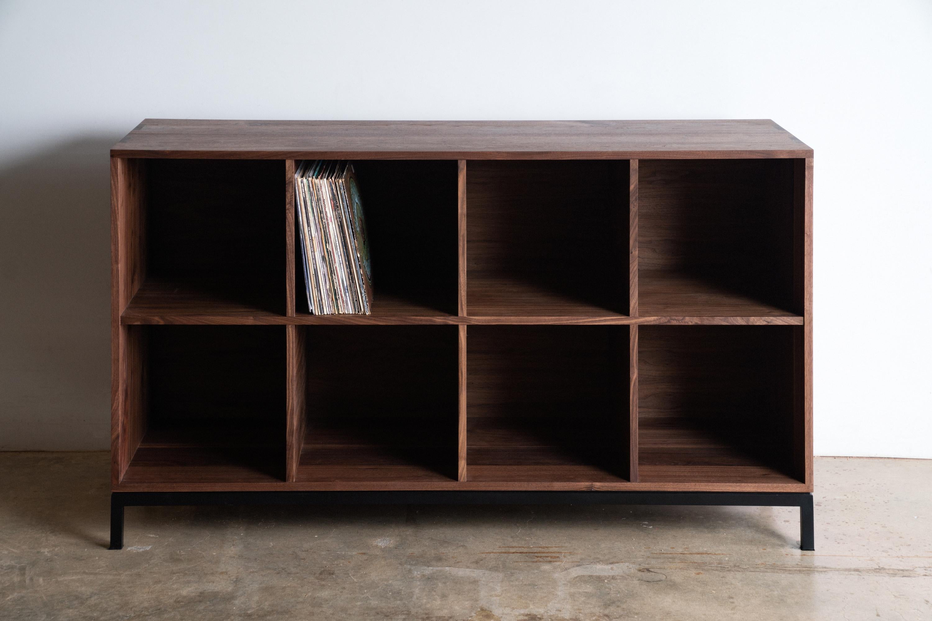 The Max Audio Storage Credenza has sleek lines and modern use of traditional joinery to act as an LP lovers vinyl record storage and a surface for audio equipment. Images shown are in Walnut Wood with Black Steel Base. Solid and plywood materials