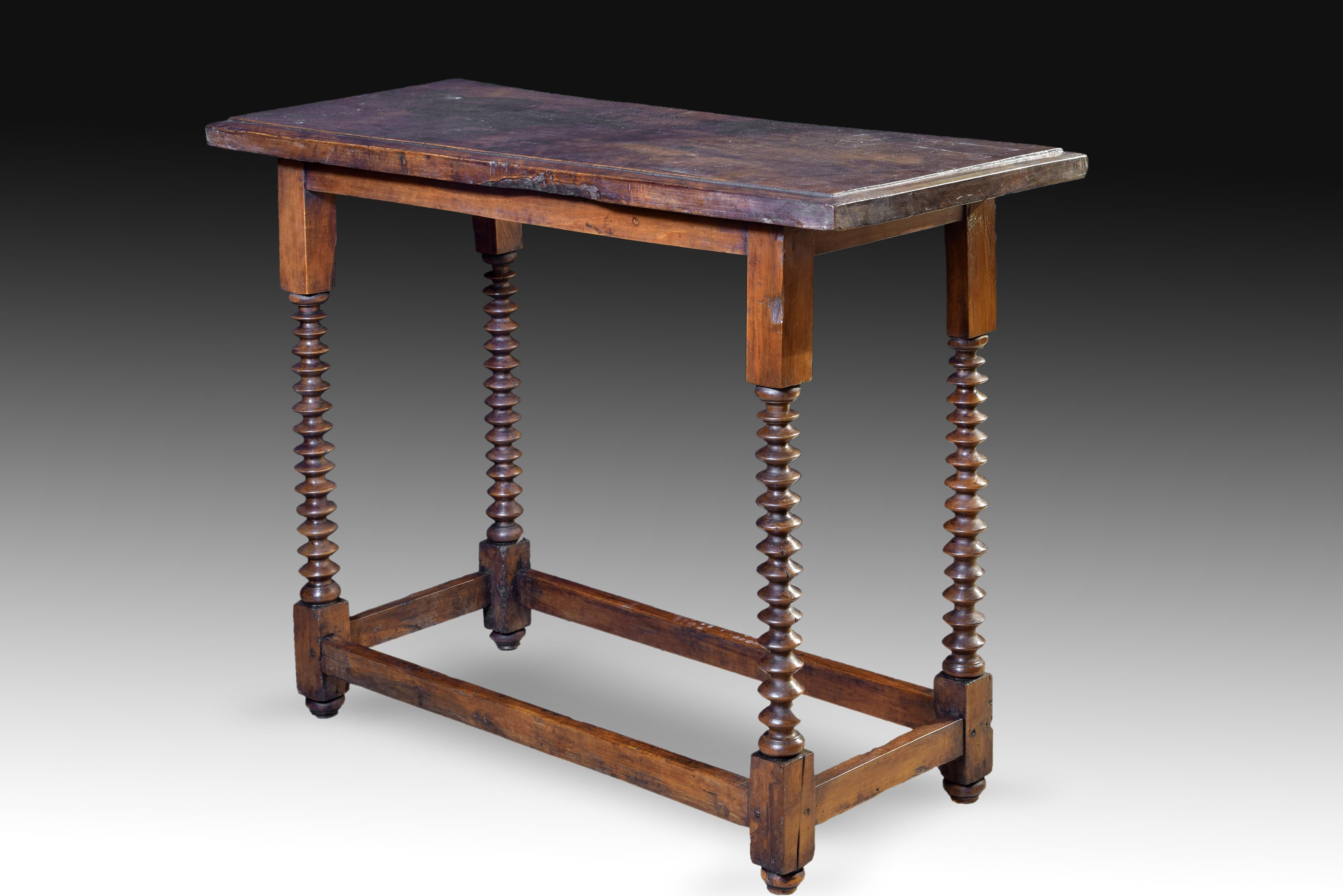 Table of rectangular and smooth top-board, with a slight recess to the outside of it, and turned legs with discs from the rectangular die of the upper part, smooth, and that of the lower area, from which two are joined by two smooth chambranas. That