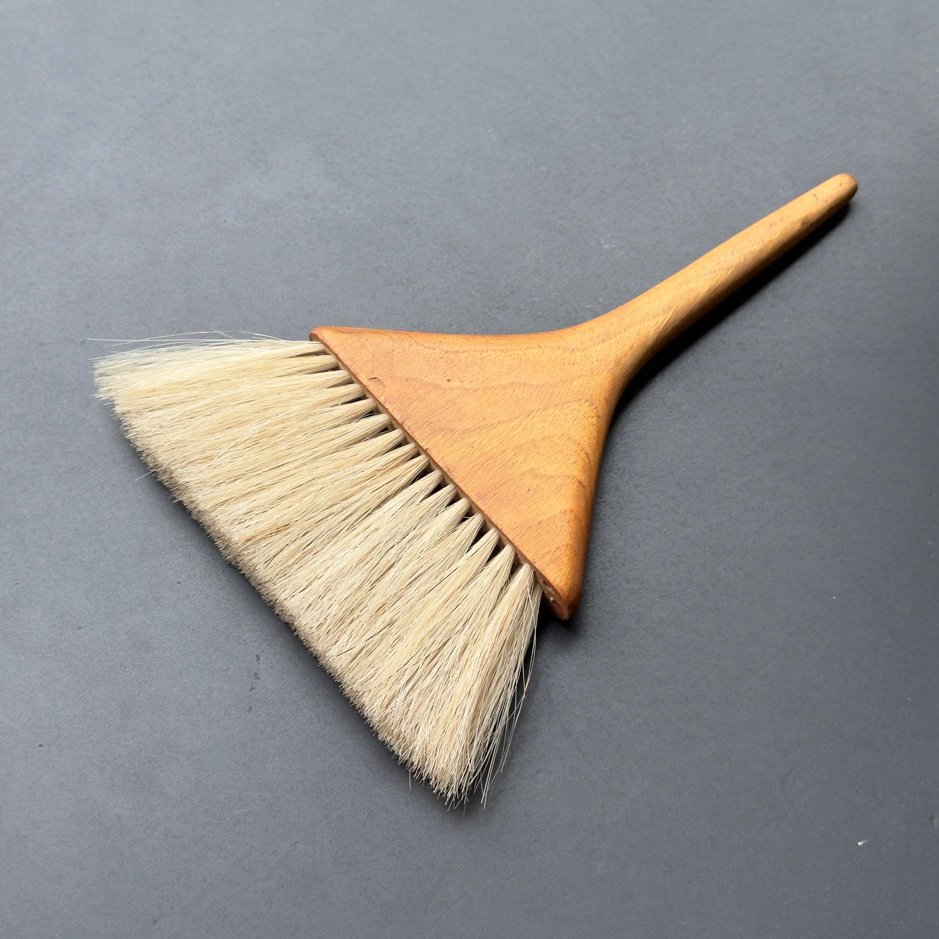 A walnut and horsehair table sweeper designed by Carl Auböck II during the late 1940s. 

This walnut table sweeper is the height of elevated everyday elegance, and its materials and construction are synonymous with the prestigious Austrian workshop.