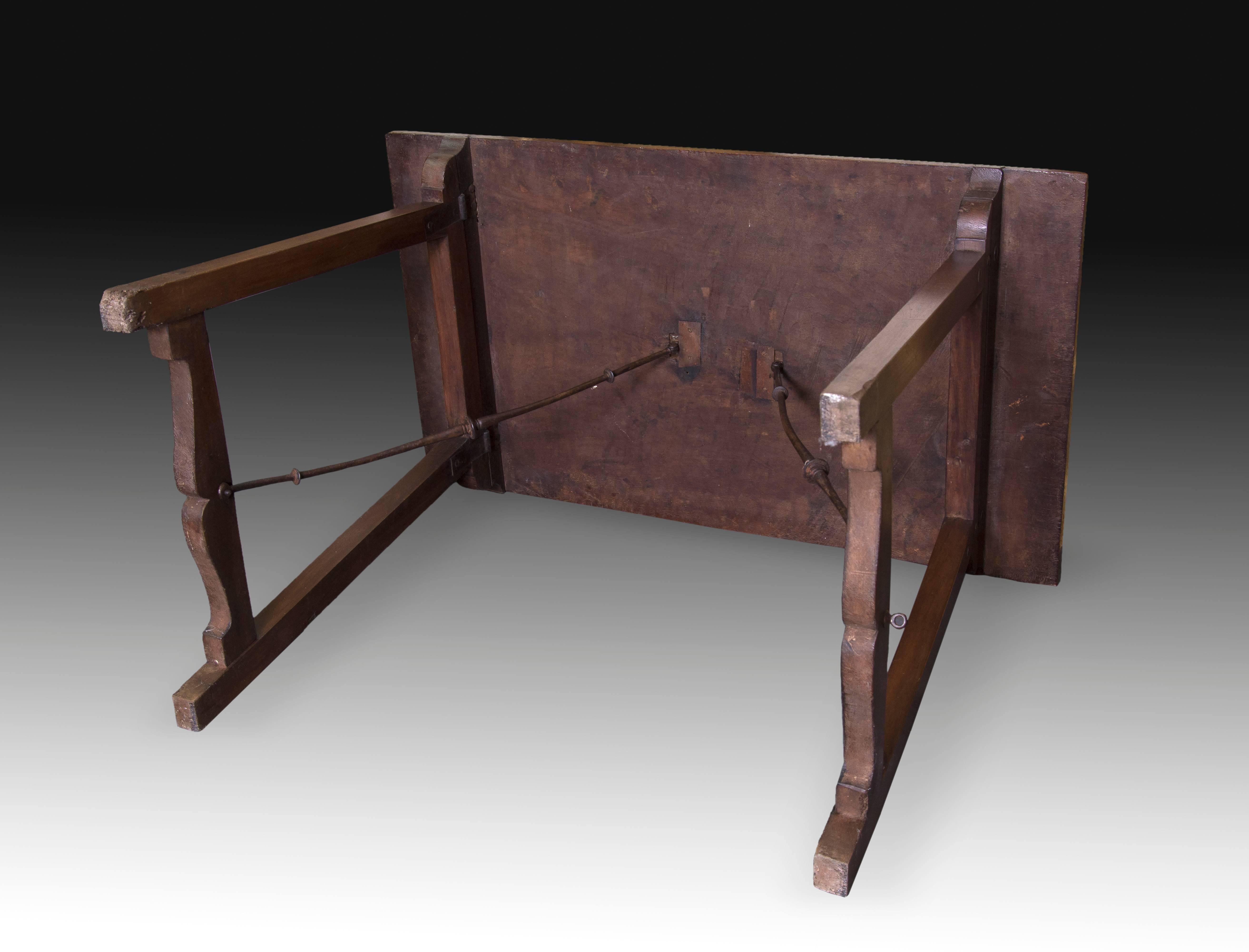 Table en noyer avec éléments en fer forgé, Espagne, XVIIe siècle.
Table en noyer avec plateau rectangulaire qui possède deux pieds de forme très particulière appelée 