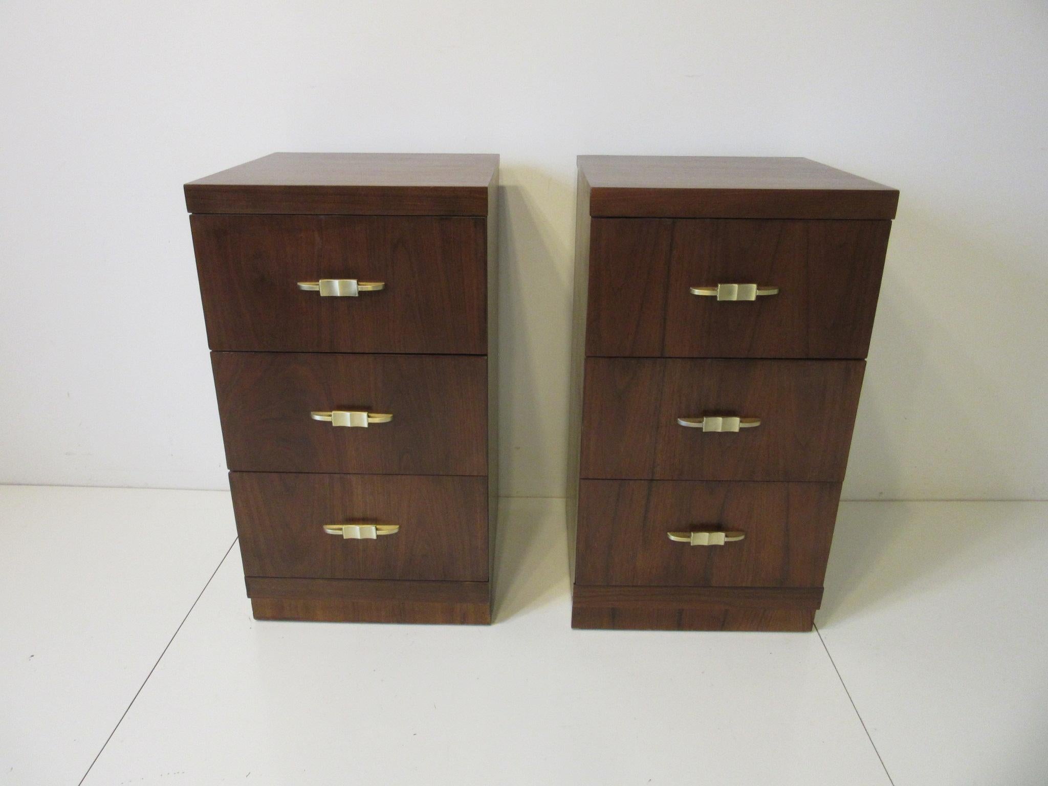 A pair of well grained rosewood three-drawer nightstands with solid cast brass pulls in a taller size perfect for today’s higher pillow top mattress and beds. A simple design that works with deco, streamline or midcentury.