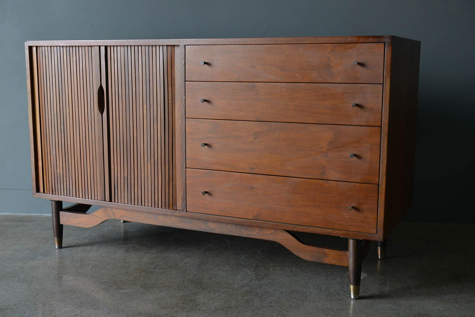 Walnut Tambour door credenza by Barzilay, ca. 1965. Beautiful walnut grain with tambour doors on the left with two originally painted white adjustable sliding drawers and 5 drawers on the right for added storage. Original drawer hardware is