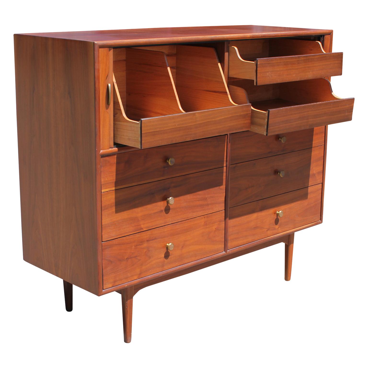 Fabulous Mid-Century Modern wood dresser or gentleman's chest with tambour doors on the front by Kipp Stewart for the Dexel Declaration line. There are storage shelves that slide out when the tambour doors slide open. It has 6 front drawers, two
