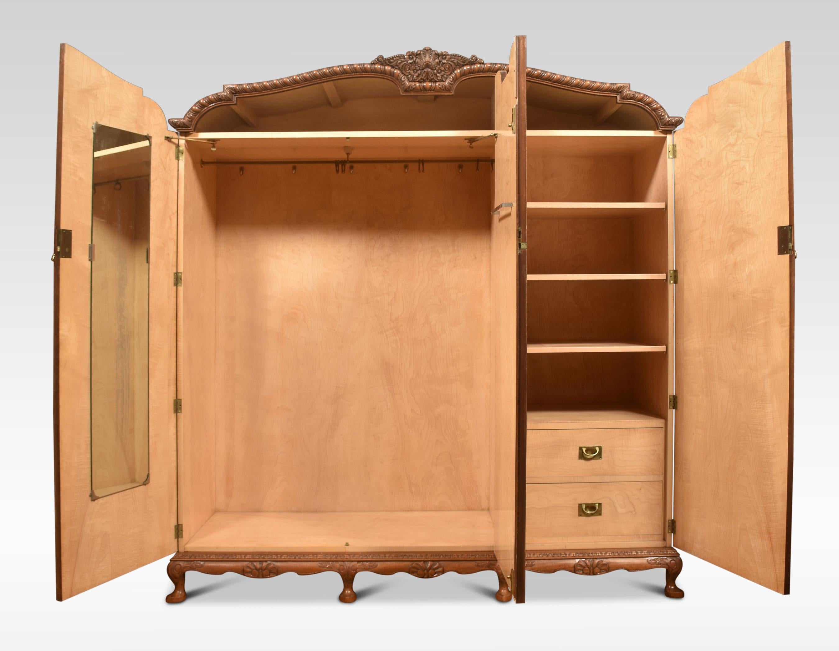 Walnut three-door combination wardrobe, the carved molded top above three long paneled well figured walnut doors opening to reveal the large hanging area to one side the other fitted with shelving and drawers. All raised up on cabriole