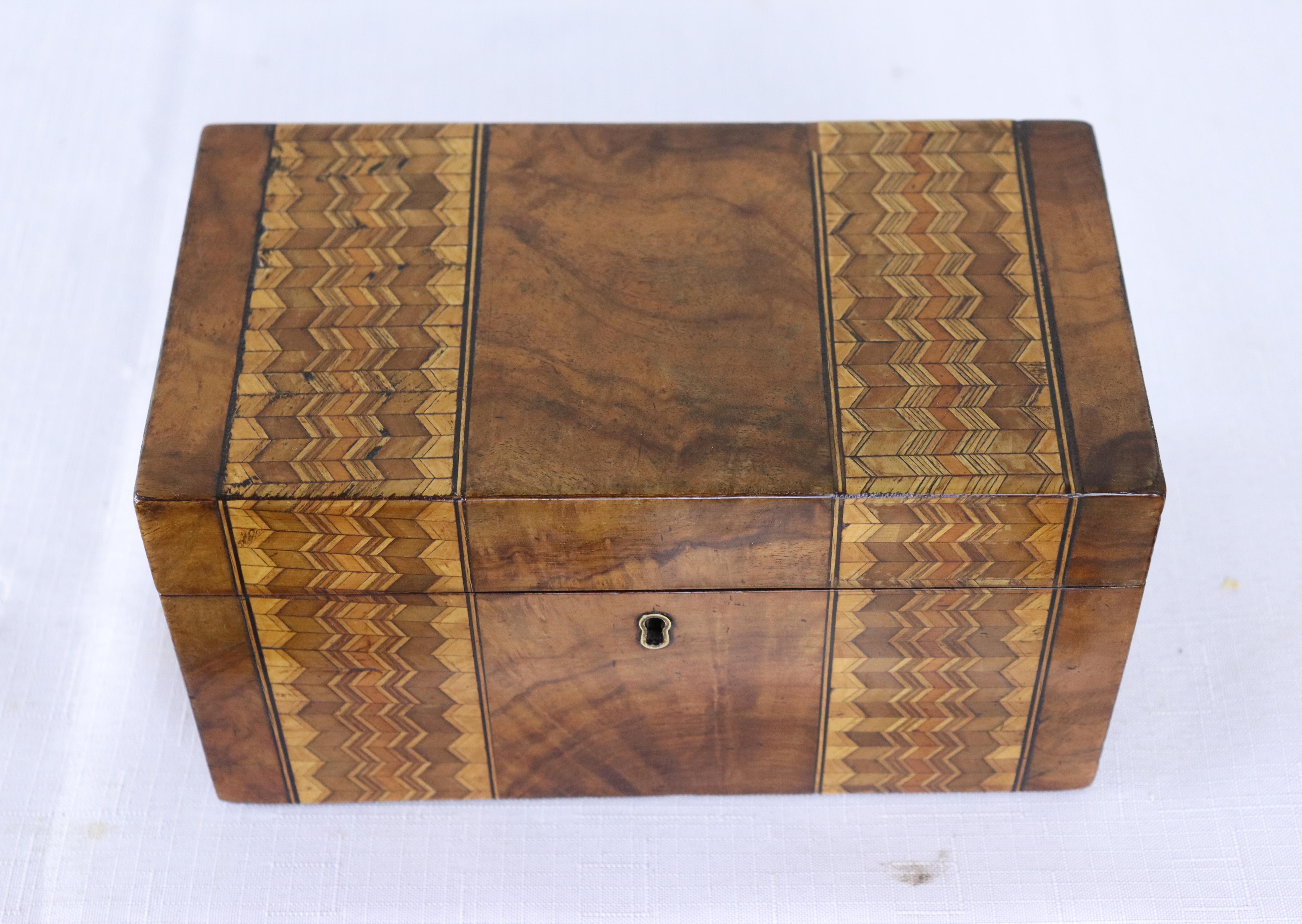 A decorative walnut Tumbridgeware tea caddy with two interior compartments. Tumbridgeware being characterized as a form of decoratively inlaid woodwork, typically in the form of boxes, that is characteristic of Tumbridge and the spa town of Royal