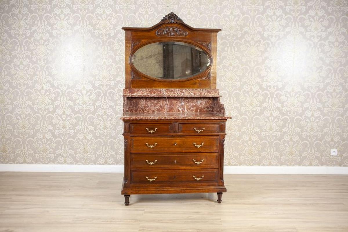 Comò in noce del periodo interbellico con piano in marmo

Ti presentiamo un mobile commode de toilette con uno specchio ovale e un piano in marmo con una mensola.
All'interno della sezione principale ci sono tre ampi cassetti. Altri due sono sotto