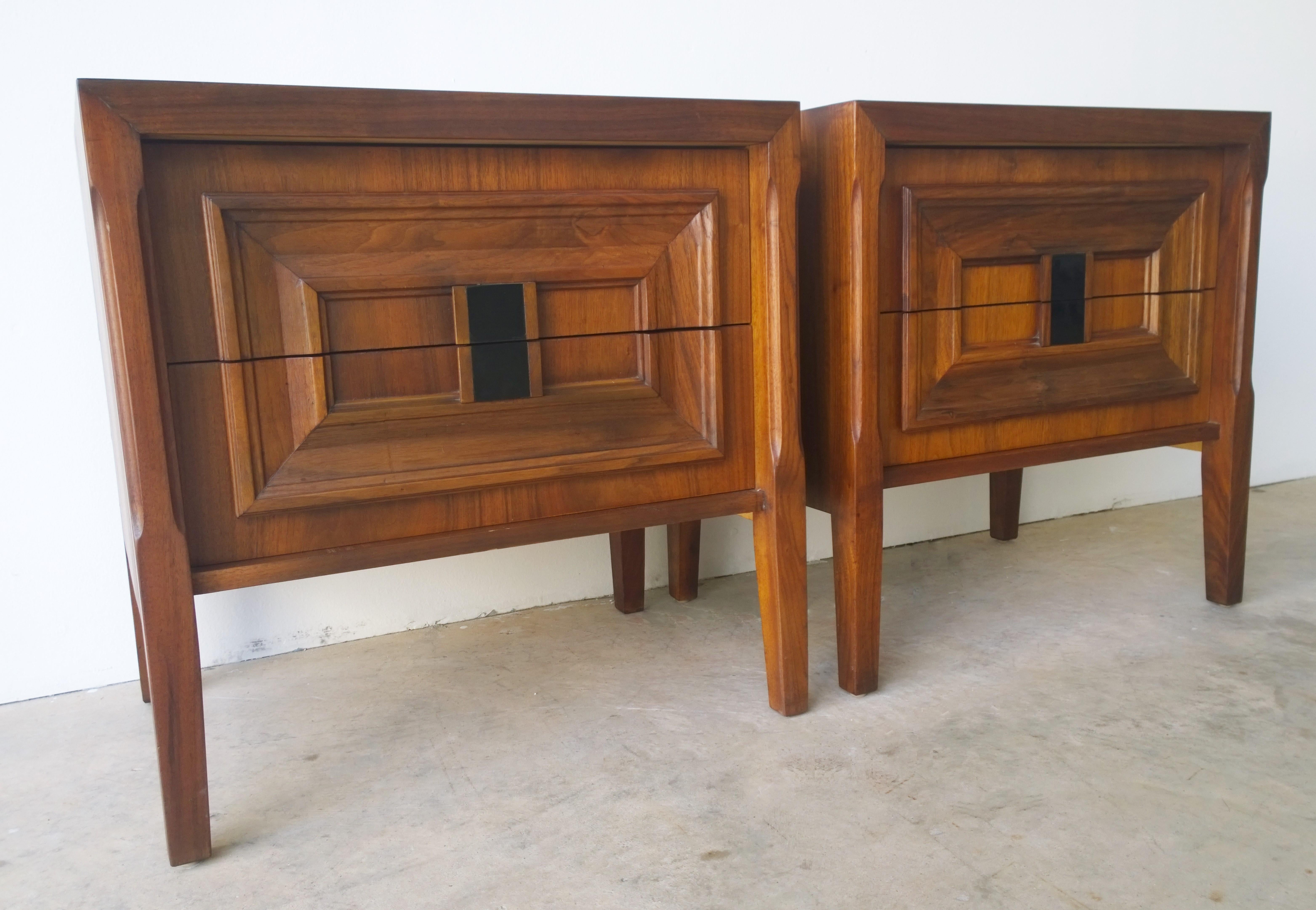 Offered are a pair of Mid-Century Modern Brutalist walnut veneer and burl wood bedside nightstands / side or end tables / chest of drawers. This set of bedside tables are box two-drawer cabinets on raised legs. The burl wood on these bedside stands